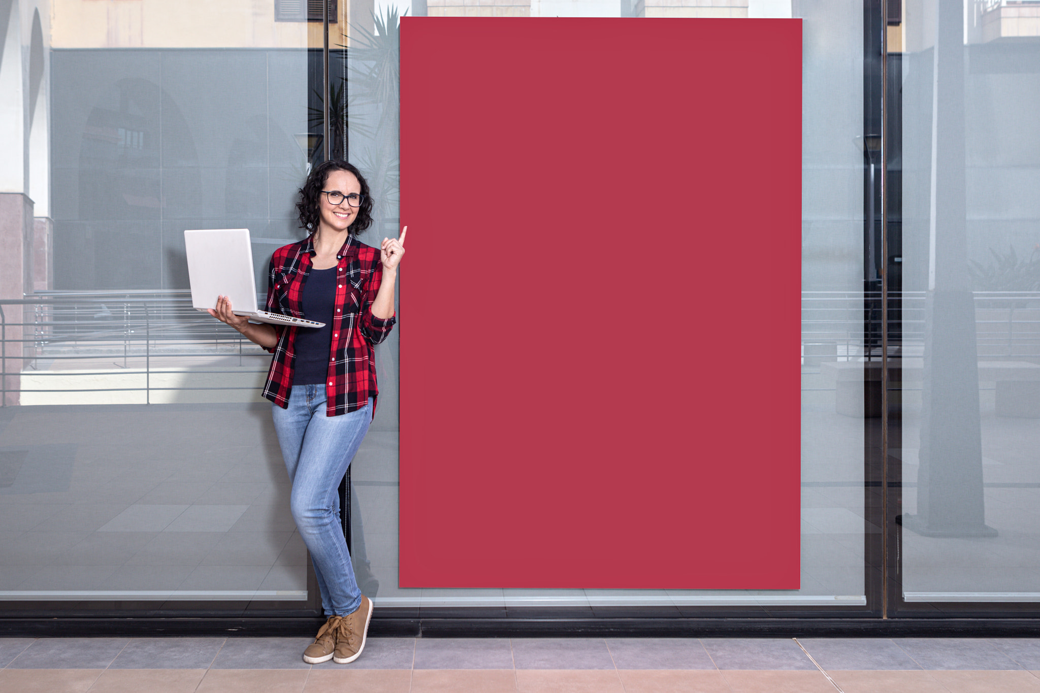 saleswoman with a laptop while pointing a red banner