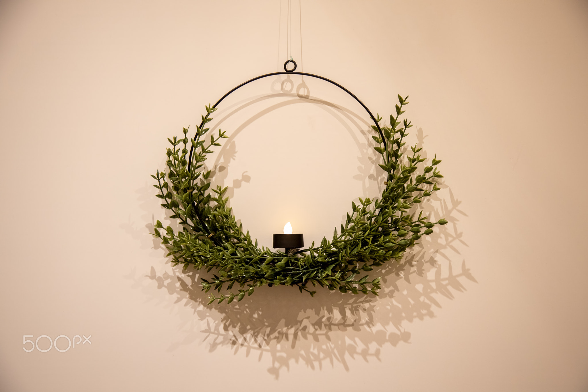 beautiful Christmas candlestick wreath on a light wall