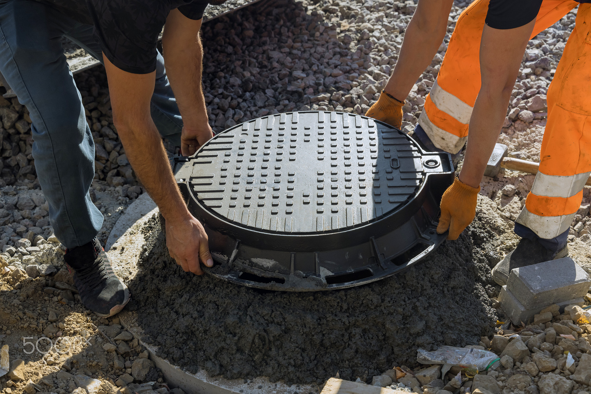 A worker installs a sewer manhole on a septic tank made of concrete