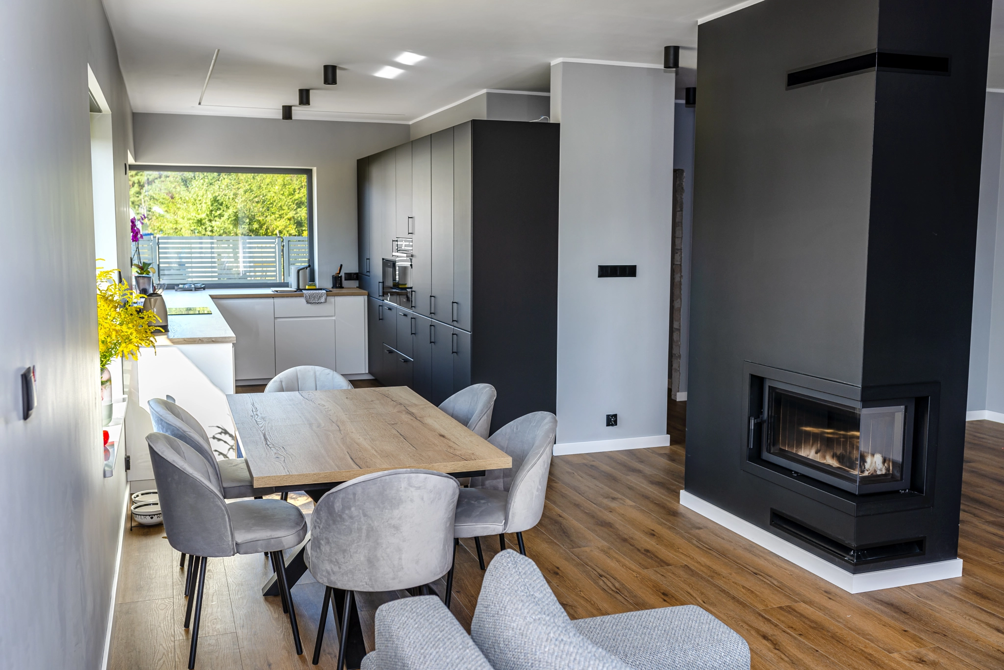 A modern dining room connected to the living room and to the kitchen.