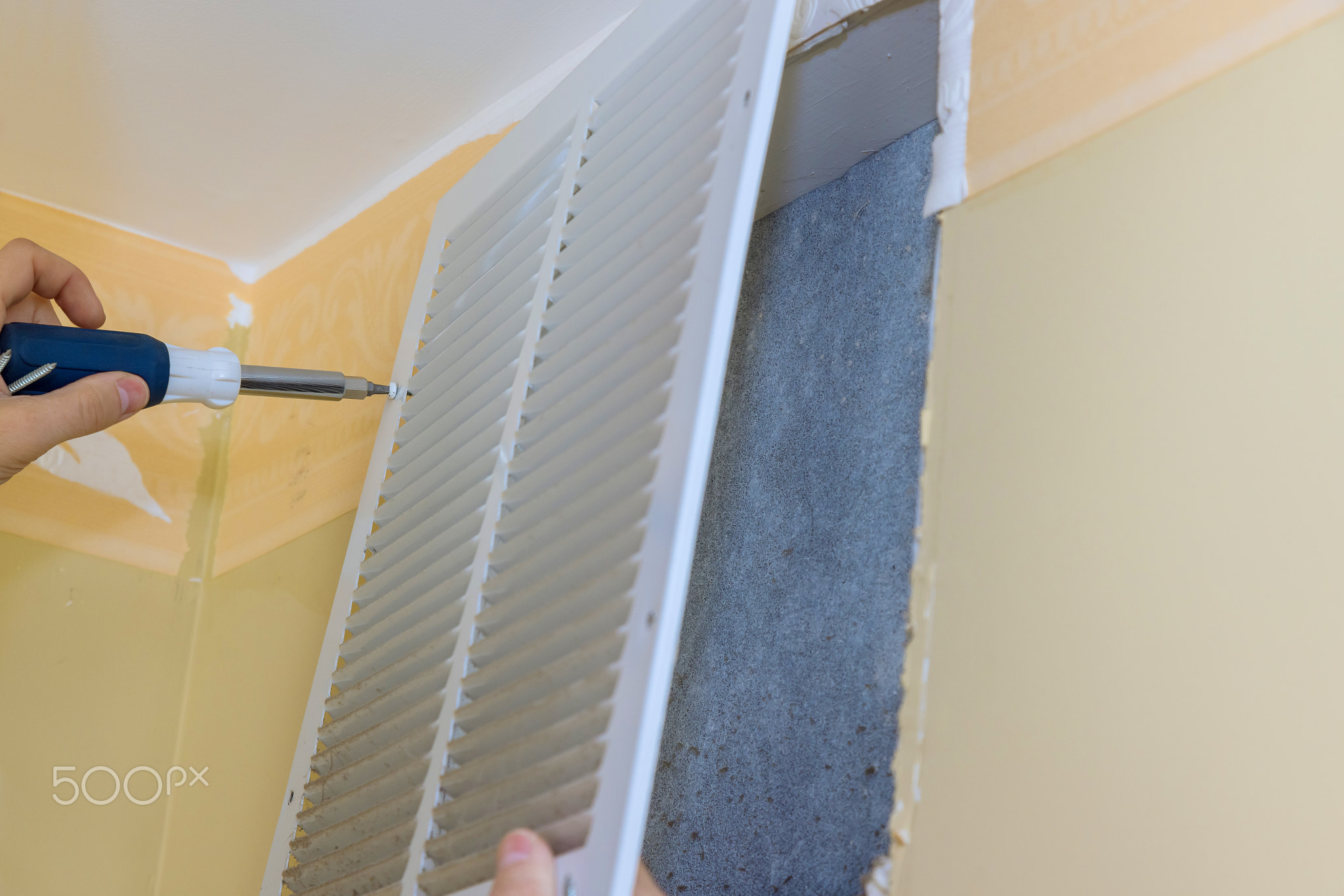 Repair in the apartment with worker removing dirty air ventilator full