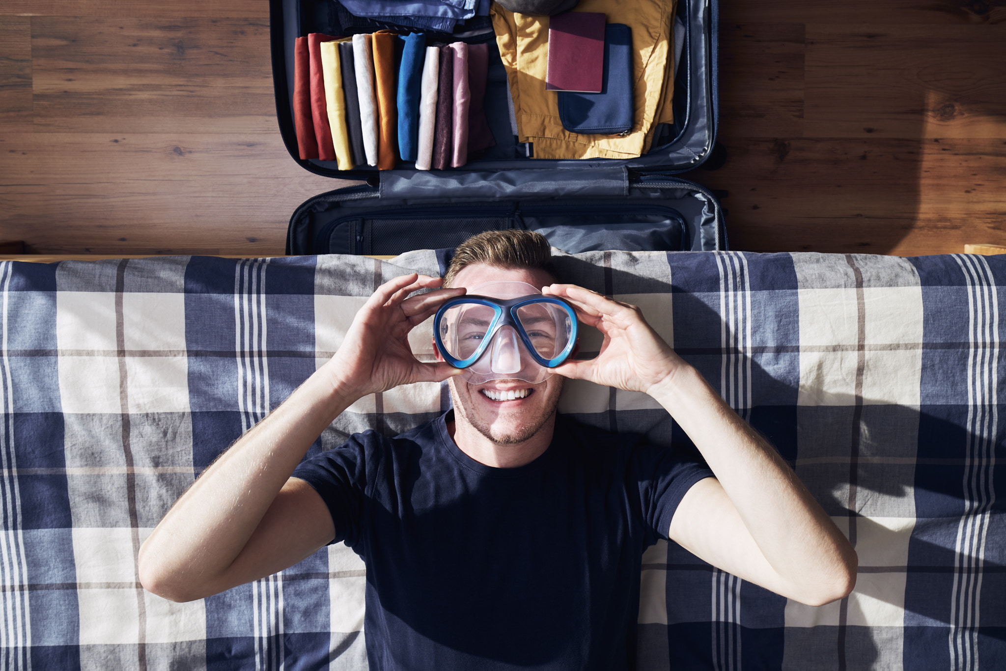 Funny portrait of happy man during packing suitcase
