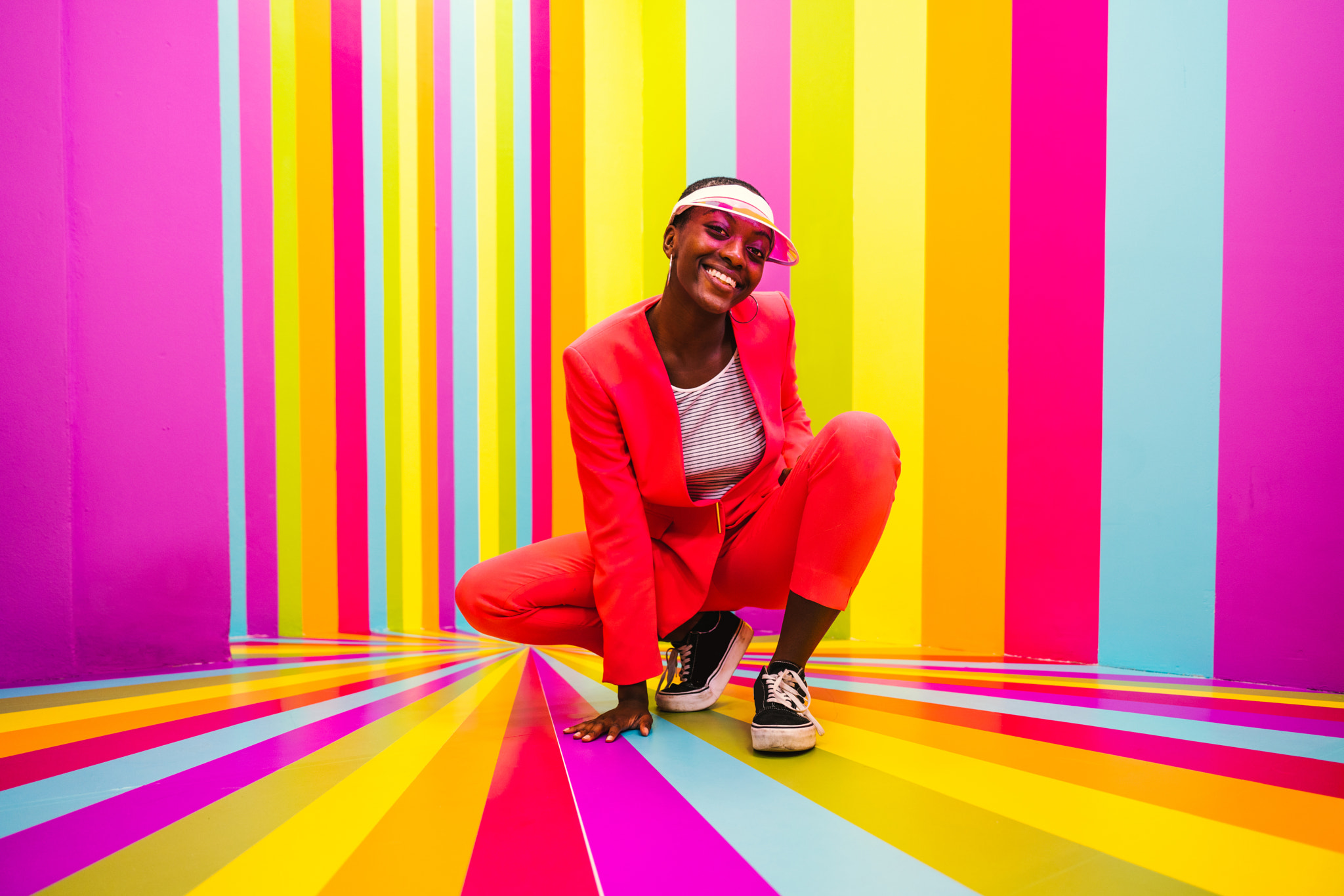 Beautiful young woman dancing and having fun inside a rainbow box room