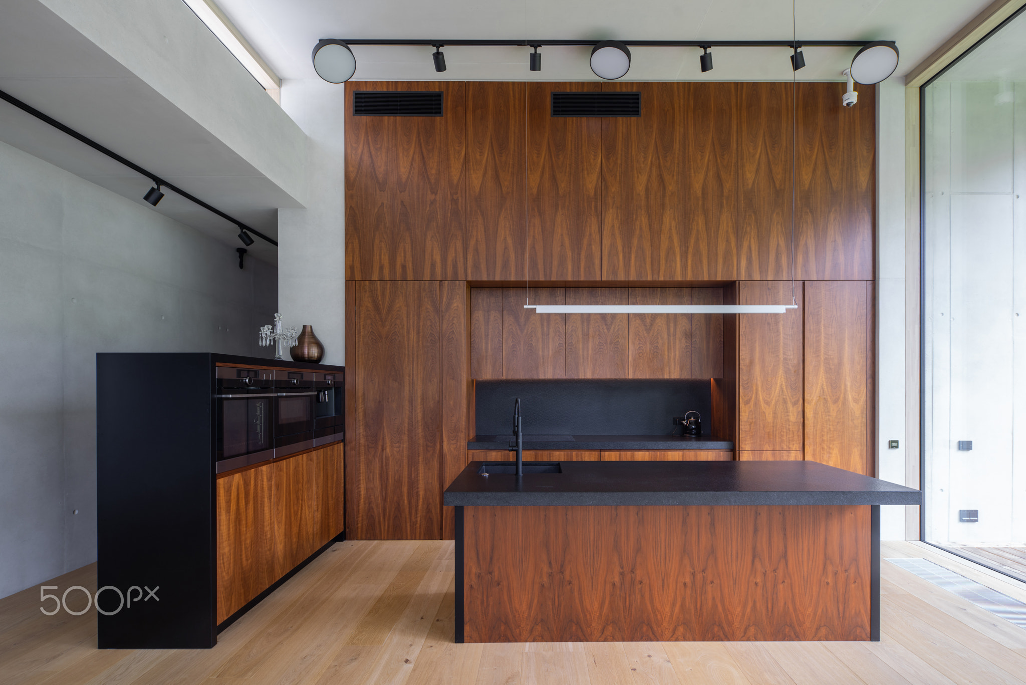Interior of modern wooden kitchen with built-in appliances in house.