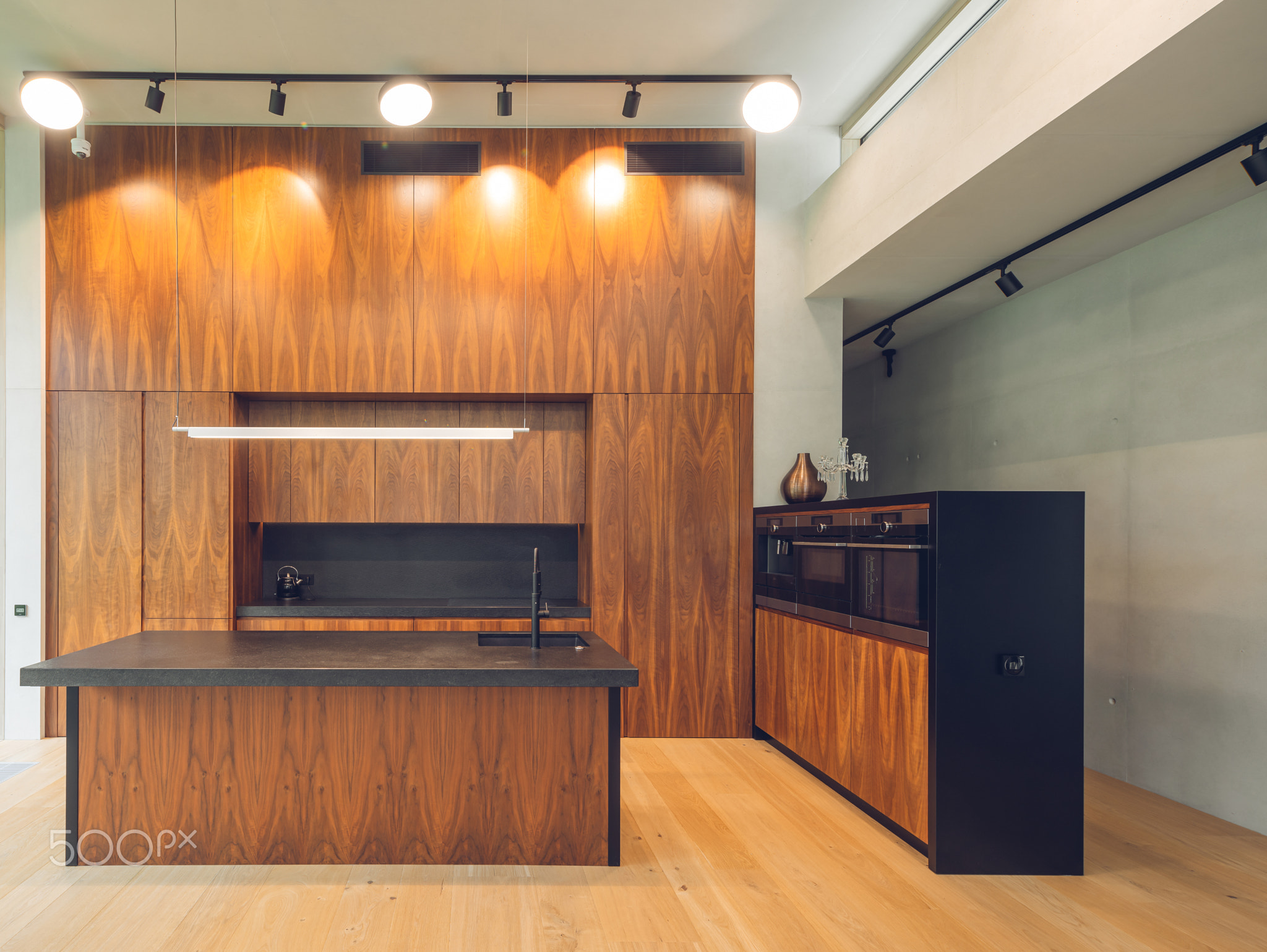 Interior of modern wooden kitchen with built-in appliances in house.