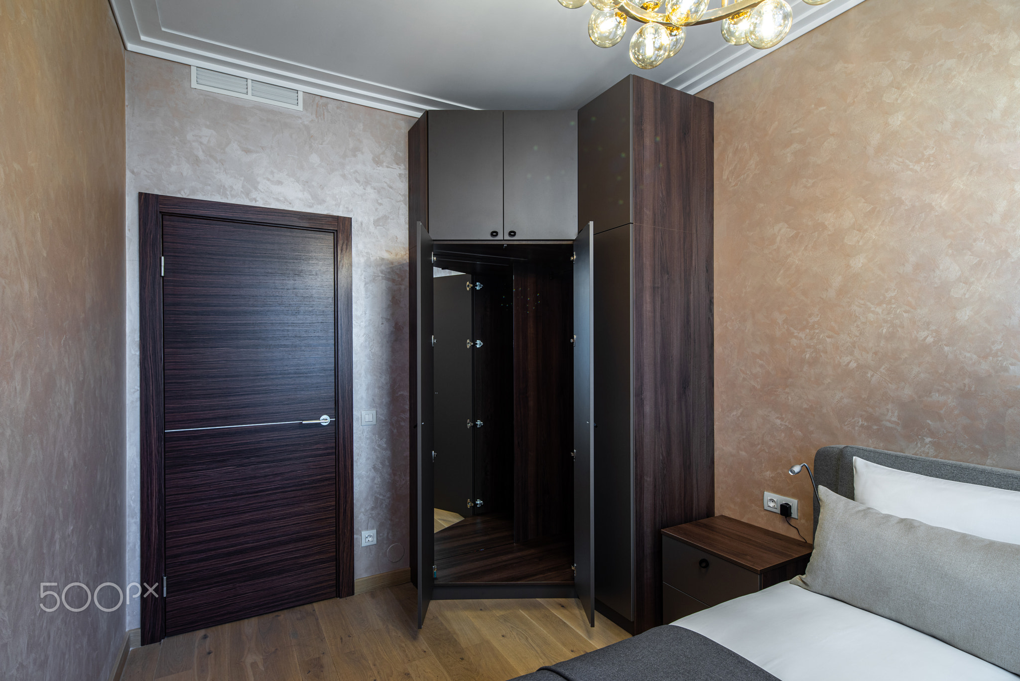 Modern interior of cozy bedroom in apartment. Brown colors.