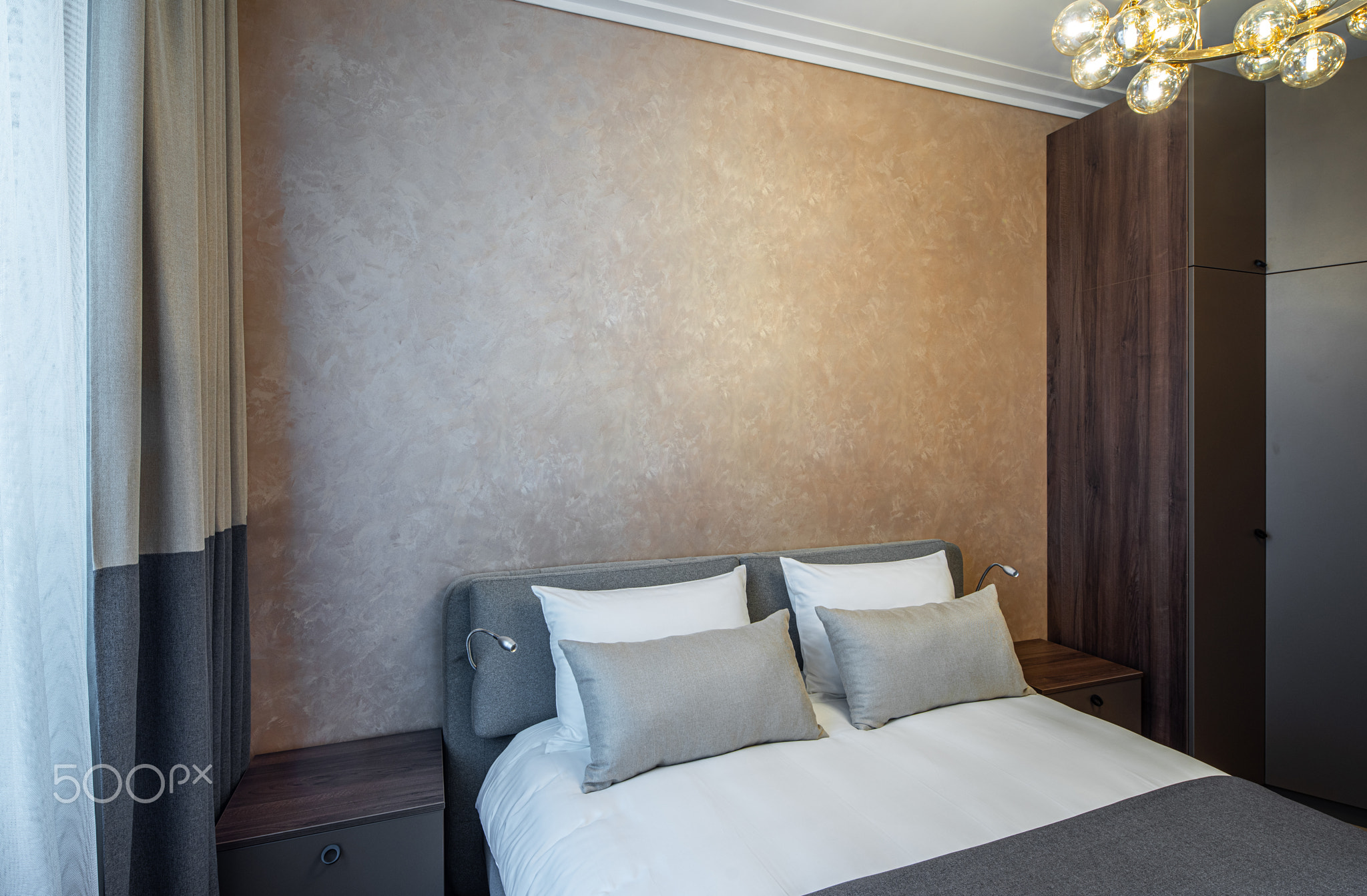 Modern interior of cozy bedroom in apartment. Brown colors.