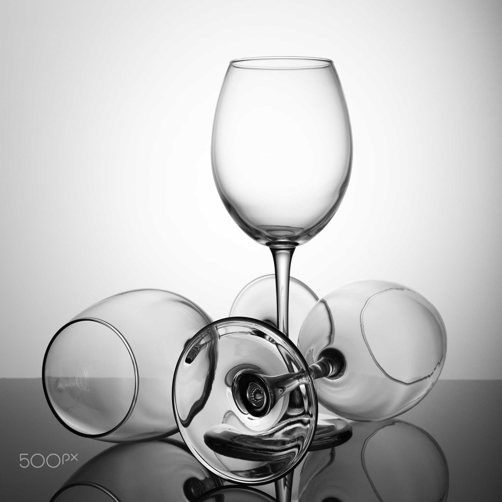 A set of empty glasses on a black table with a reflection