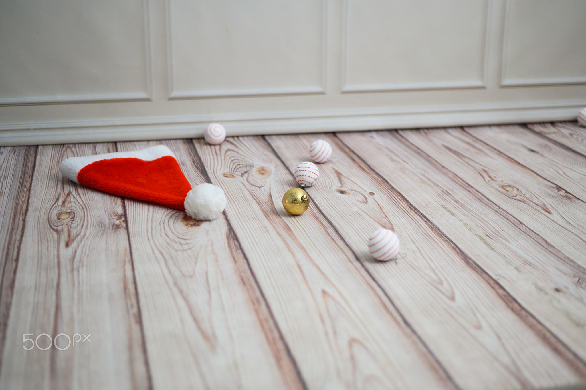 Santa's helper's hat and Christmas tree toys are lying on the floor.