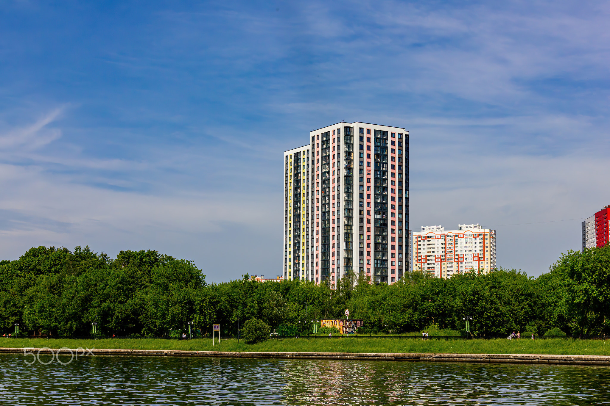 View of the river bank with buildings in summer