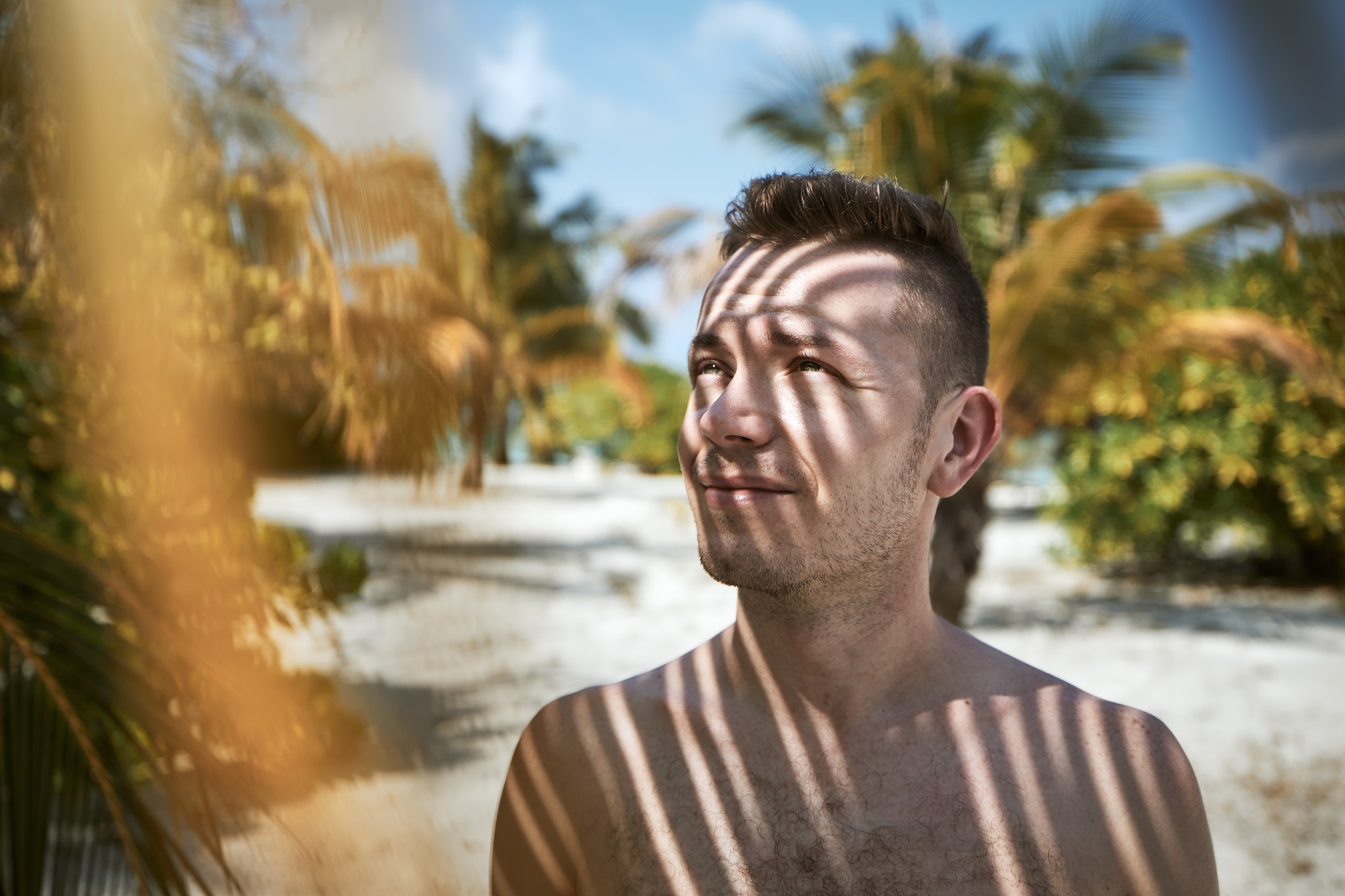 Portrait of young man under palm tree