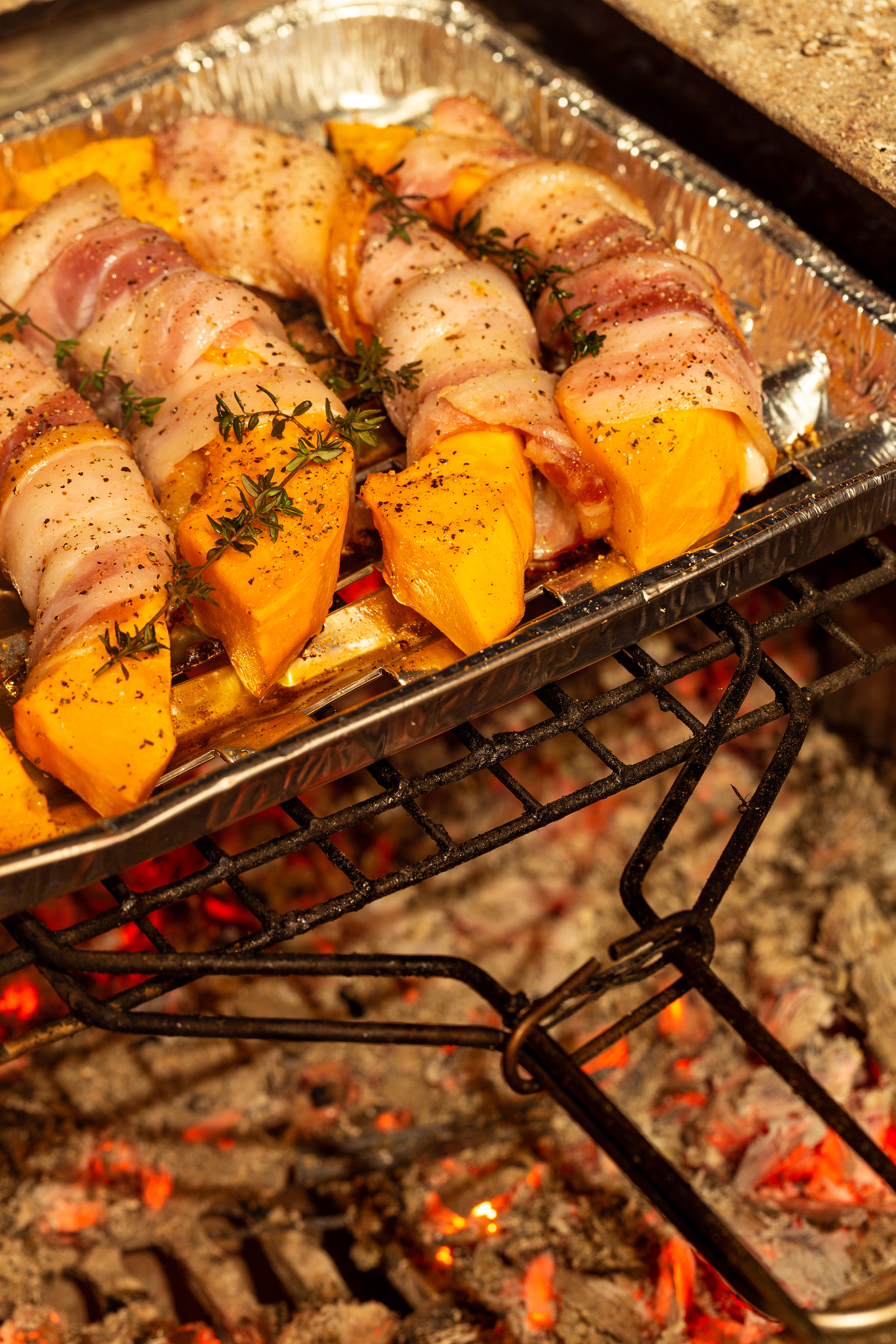 Tasty pumpkin slices wrapped in bacon baked on a grill