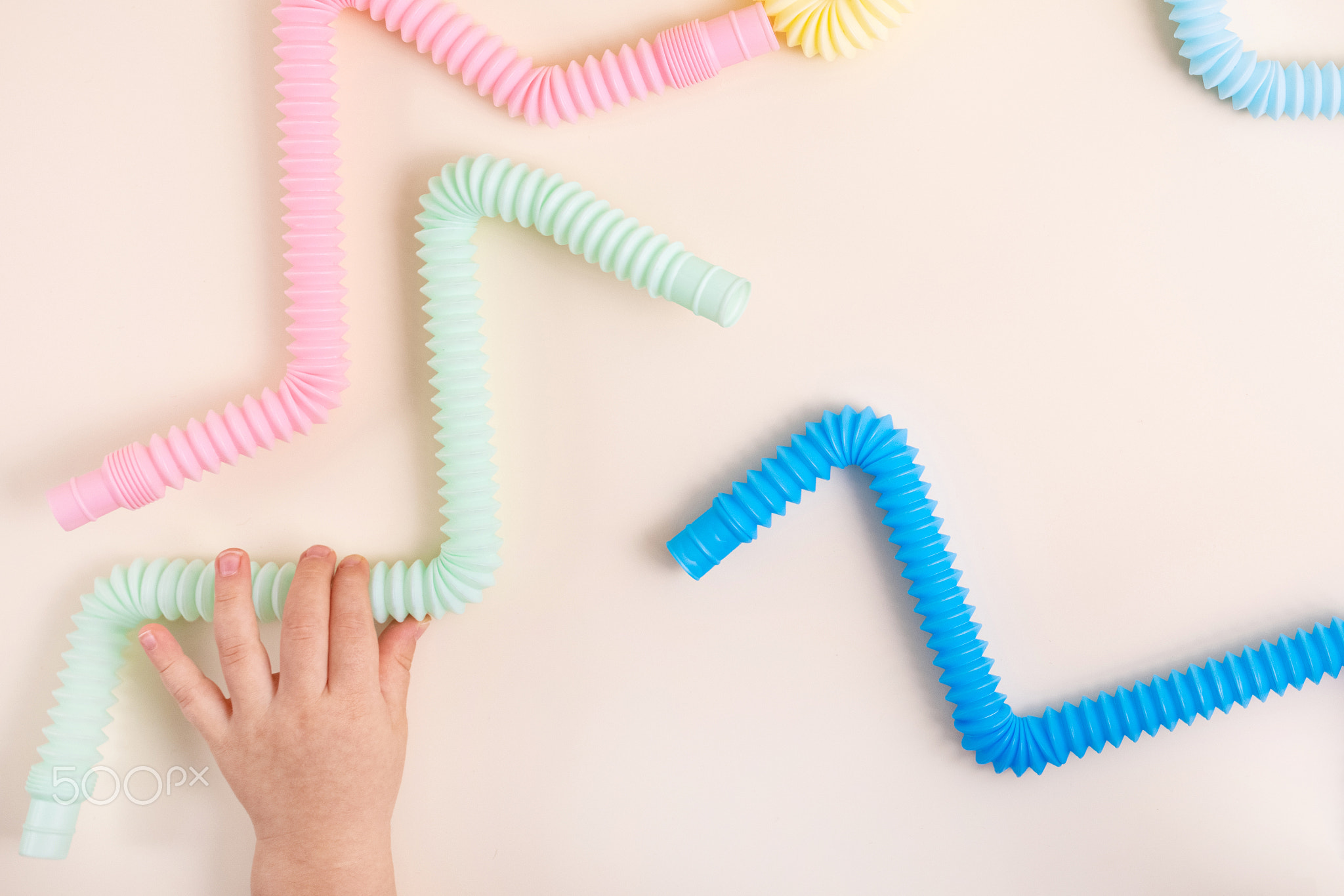 Trendy kids toys pastel colorful pop-tube in baby toddler hands on