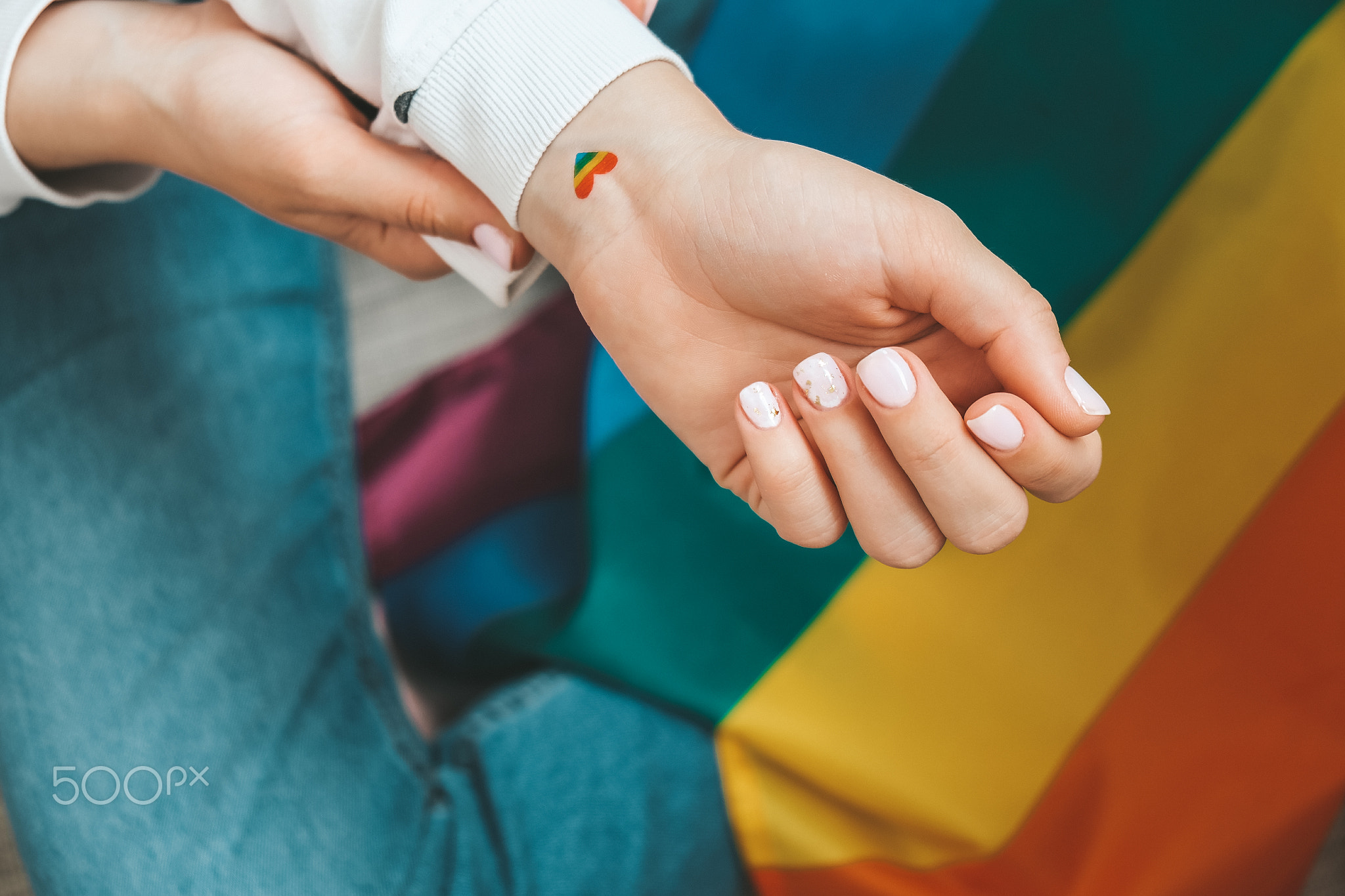 Closeup of young caucasian millennial hippie woman with a rainbow flag