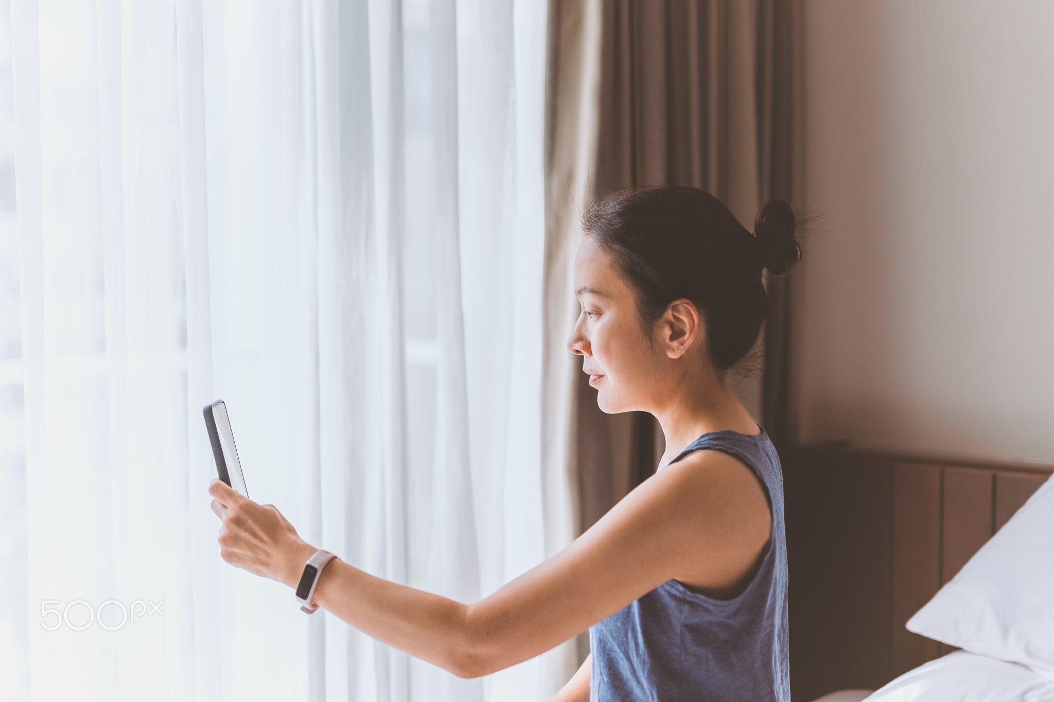 Portrait of serious woman sit on the bed making video call on smart