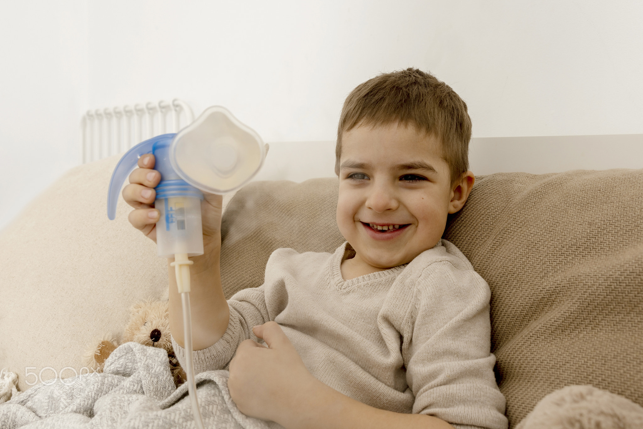 Sick little boy with inhaler for cough treatment. Unwell kid doing