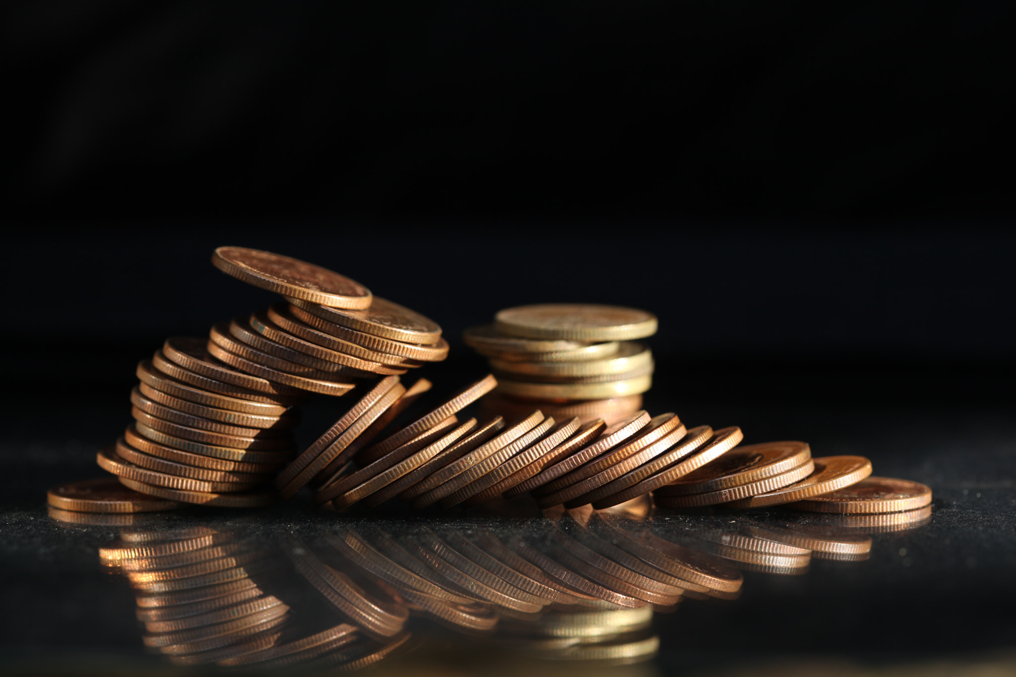 A vertical shot of a pile of golden coins and copper coins.