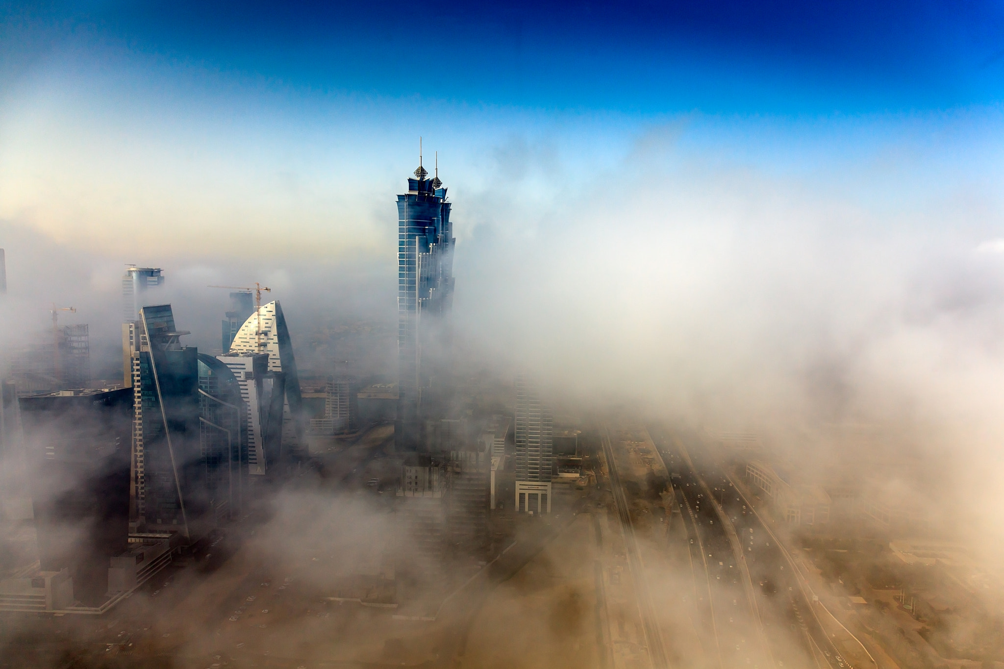 Early morning fog is covering Dubai business bay area.