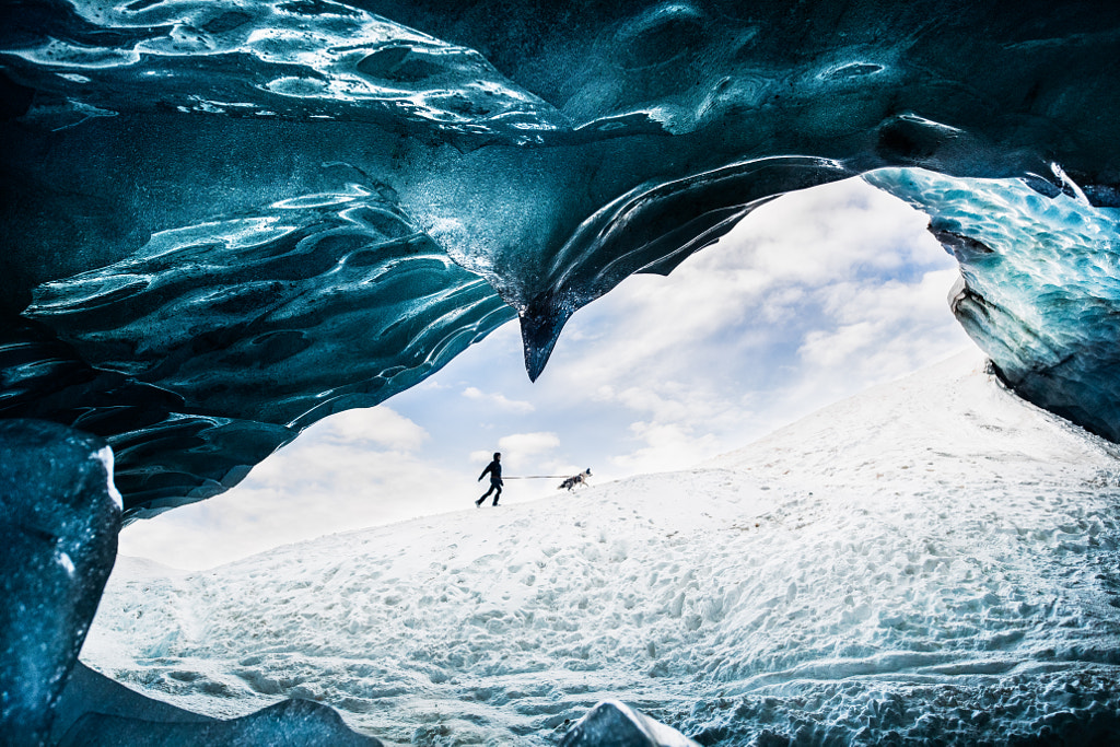 Iza tarafından Buz Mağarası altında köpekle yürüyen adam ?yso?  500px.com'da