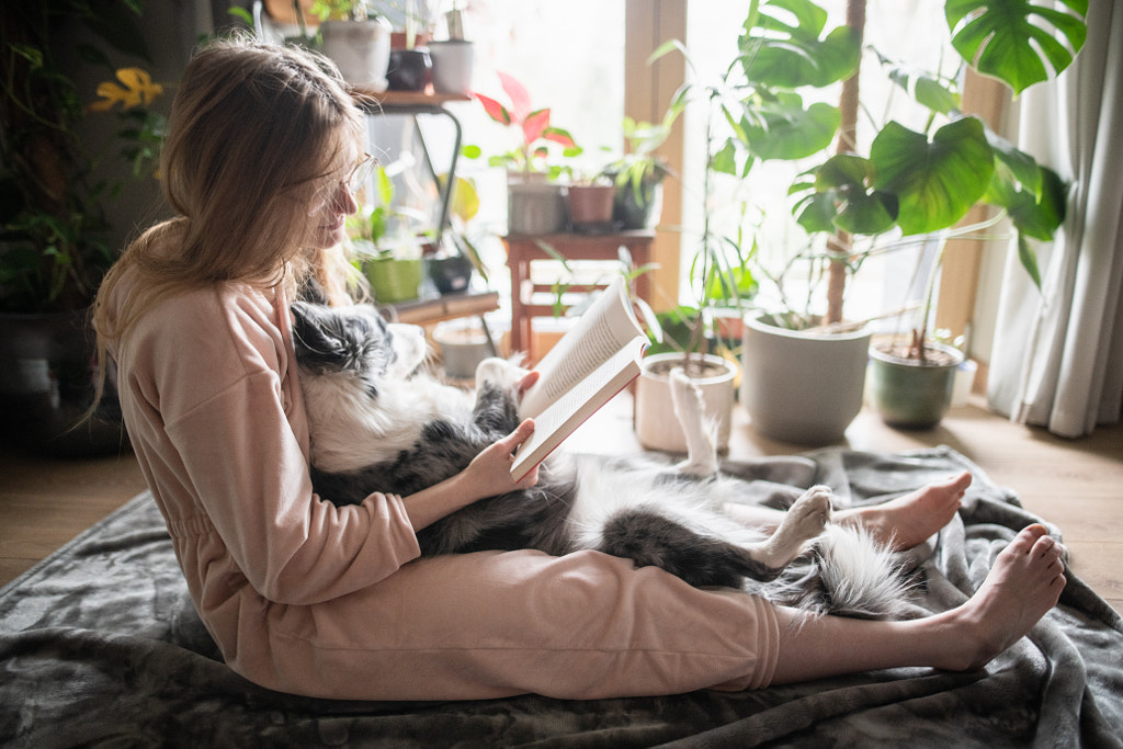 Genç kadınlar rahat bir sabah geçiriyorlar - Iza ?yso'nun bir köpeğiyle kitap okuyorlar.  500px.com'da