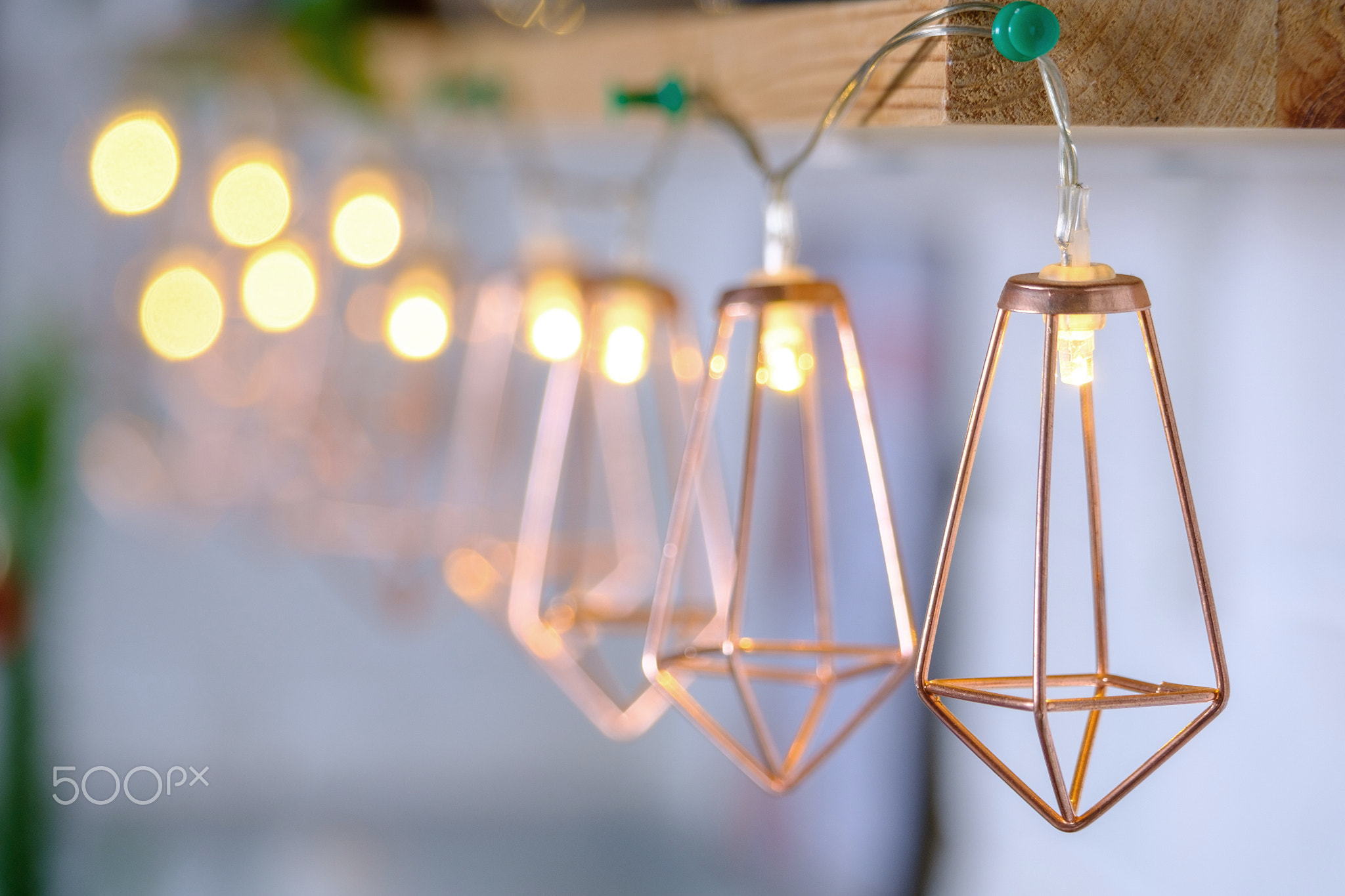 Extrimely close-up metallic gold garland glowing with warm light on