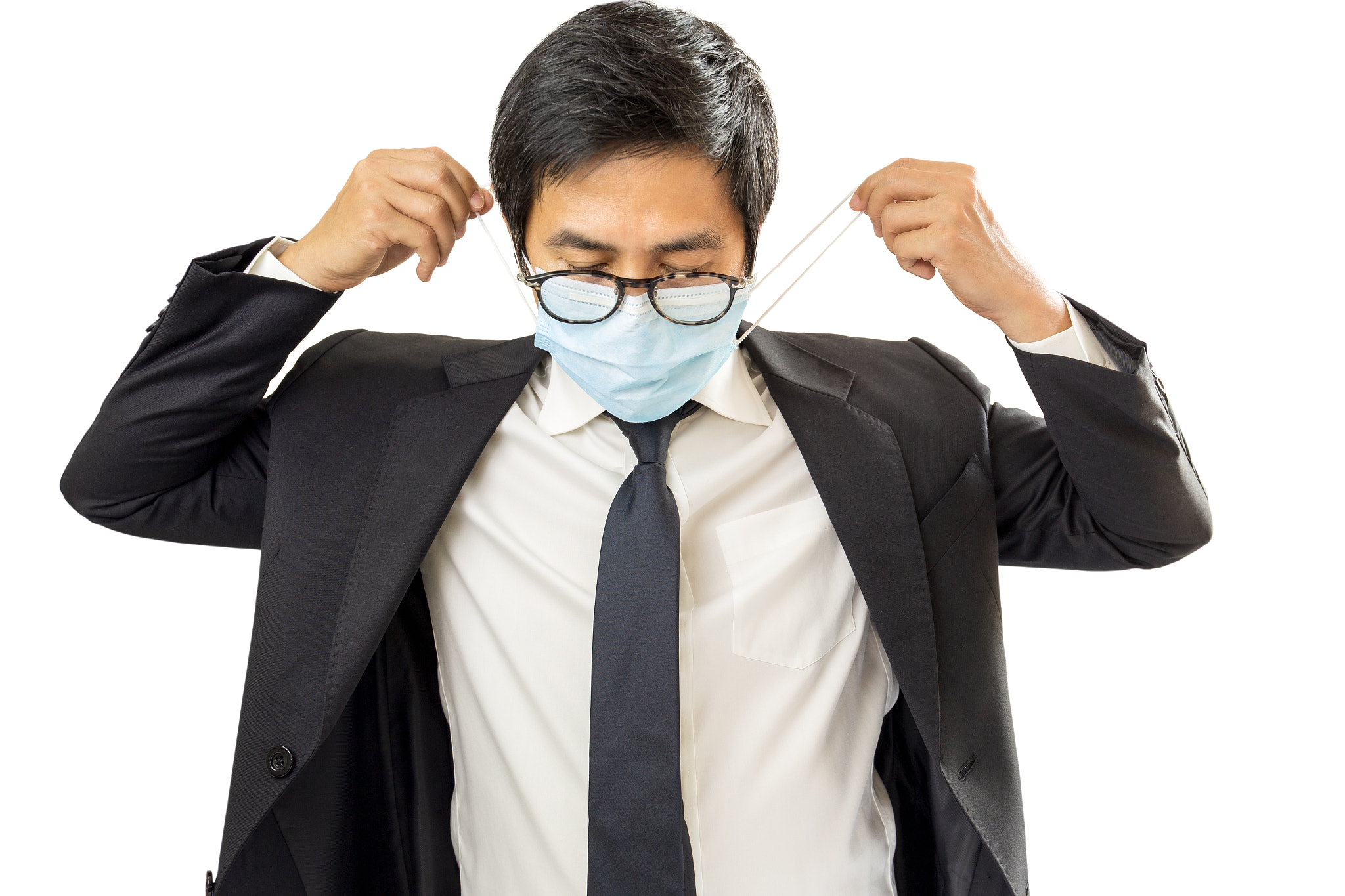 Businessman putting protective mask on his face in white background.