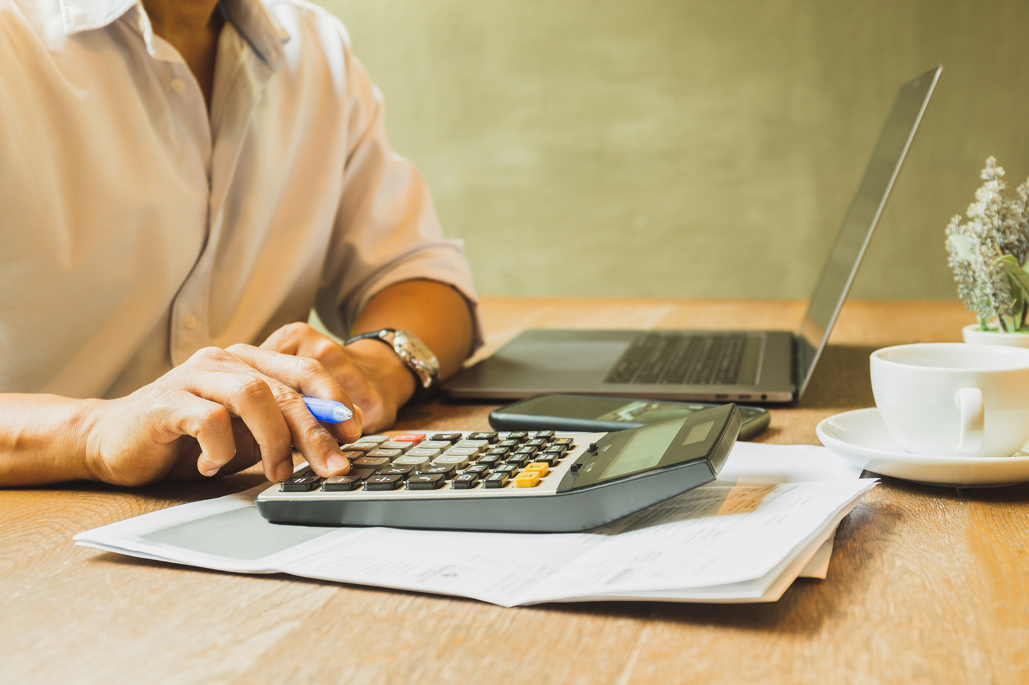 Businessman analyzing investment using calculator for calculate.