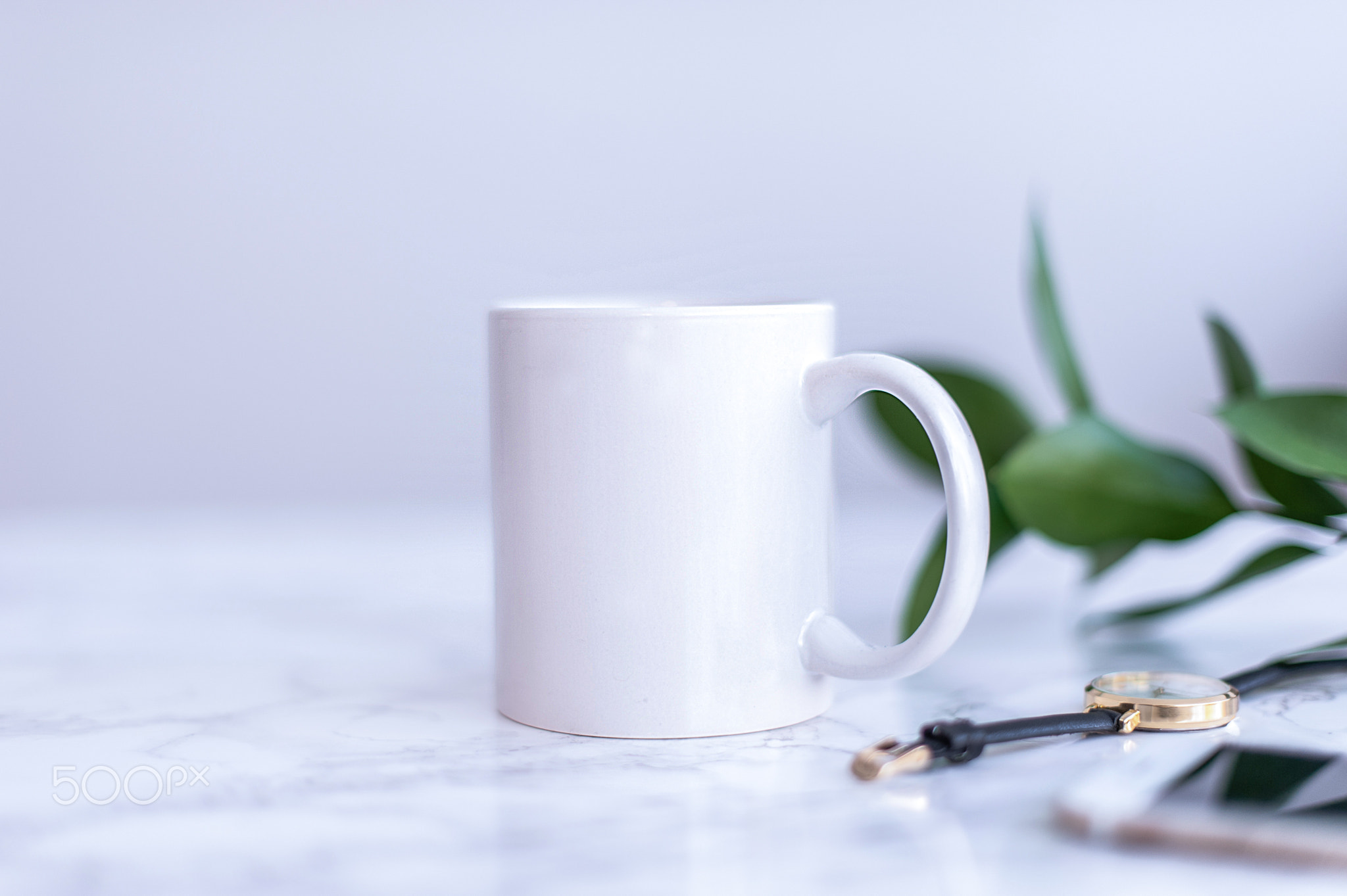 A white mug with black coffee on a white countertop. Side view