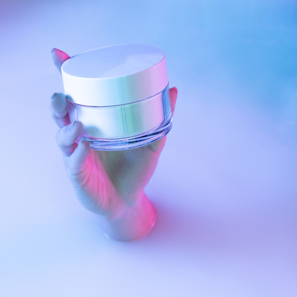 Close up female hand holding cosmetic jar appears from milk bath with by Volodymyr Melnyk on 500px.com