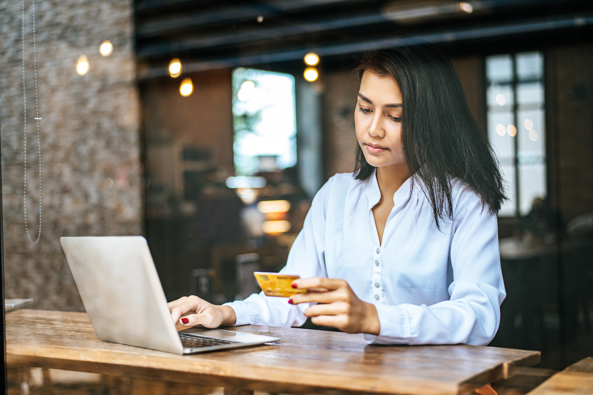 woman sitting thinking about credit card balances,notebook.