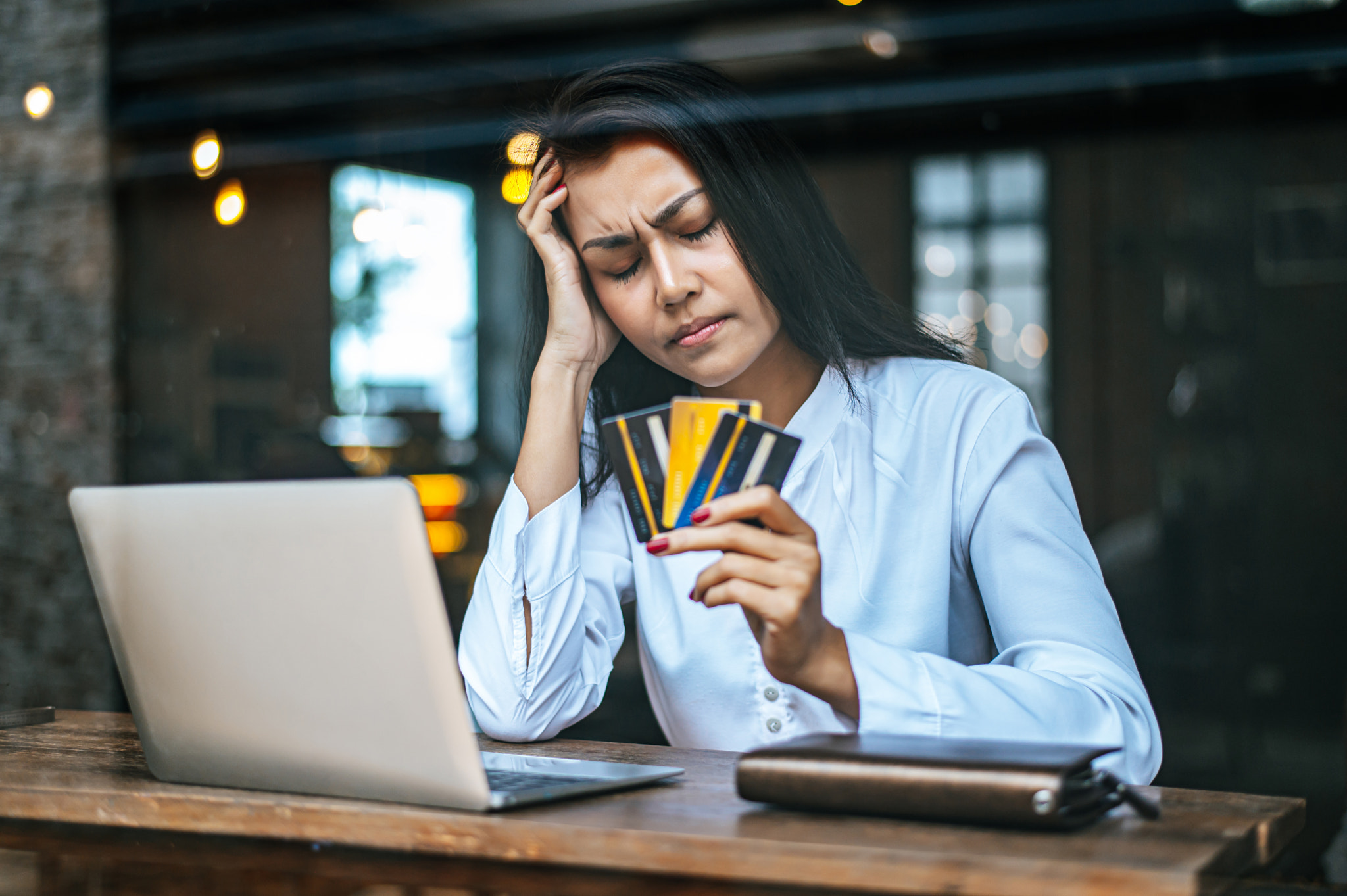 woman sitting thinking about credit card balances,notebook.