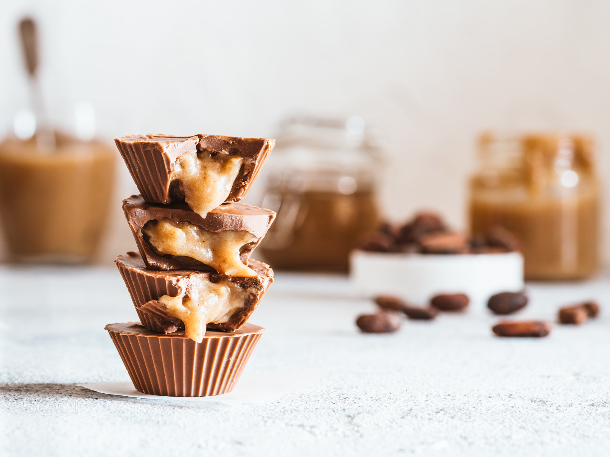 Stack of vegan chocolate cups with caramel on white