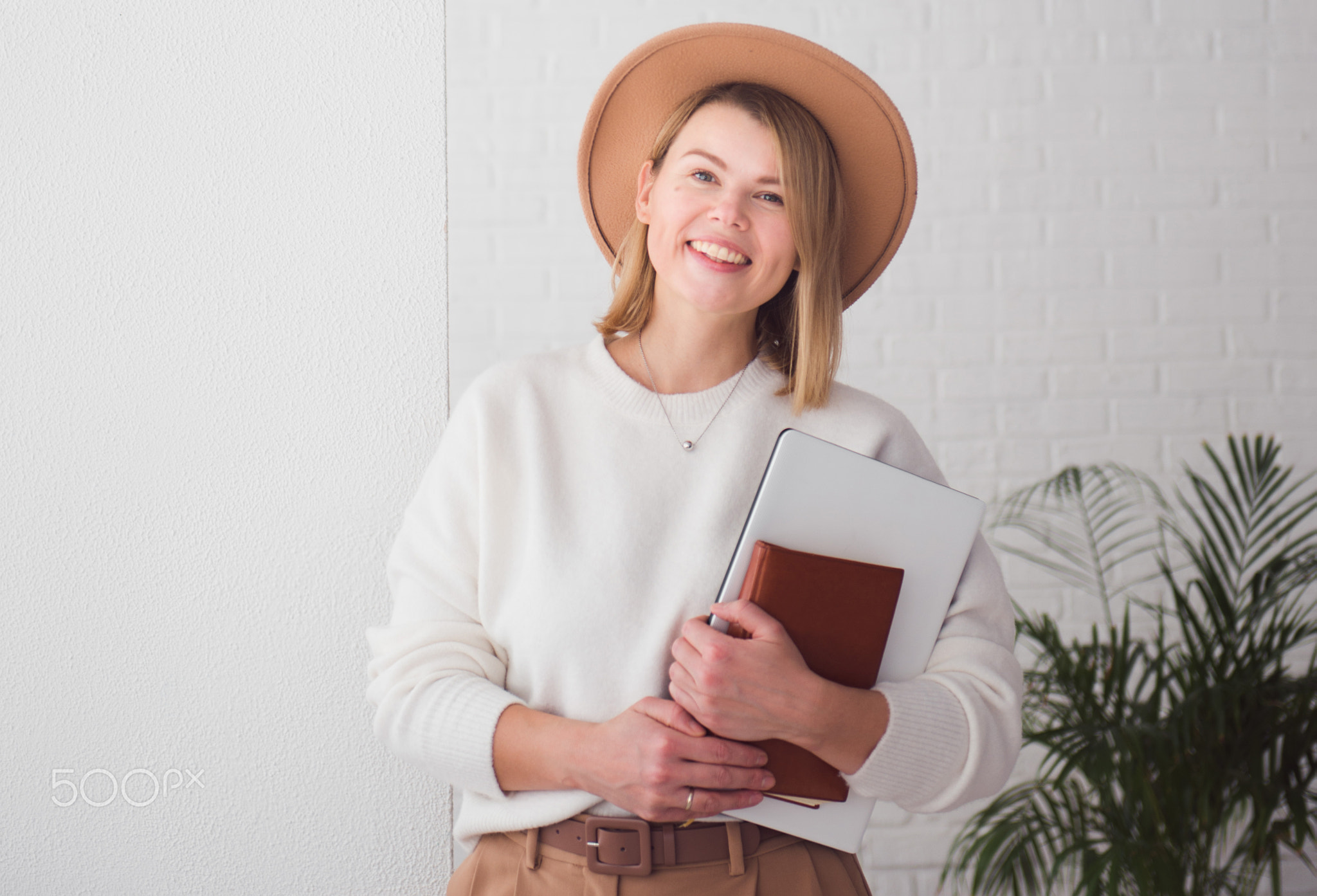 stylish woman holding notebook and copybook, smiling and looking at