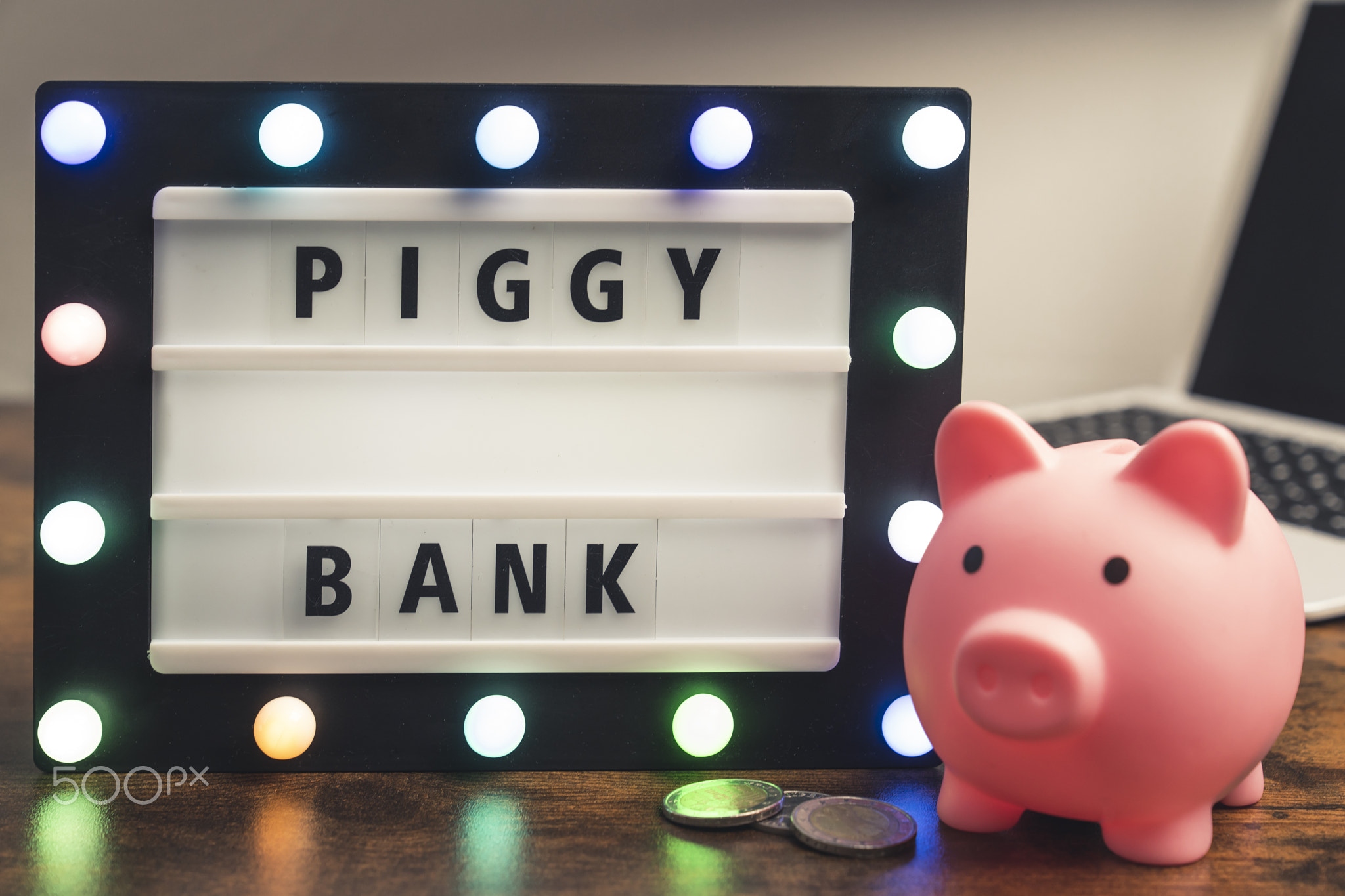 Piggy bank word written on marquee lightbox - savings concept