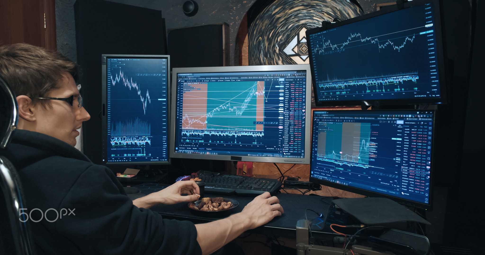 Male trader, freelancer on stock exchange trades options and eats nuts