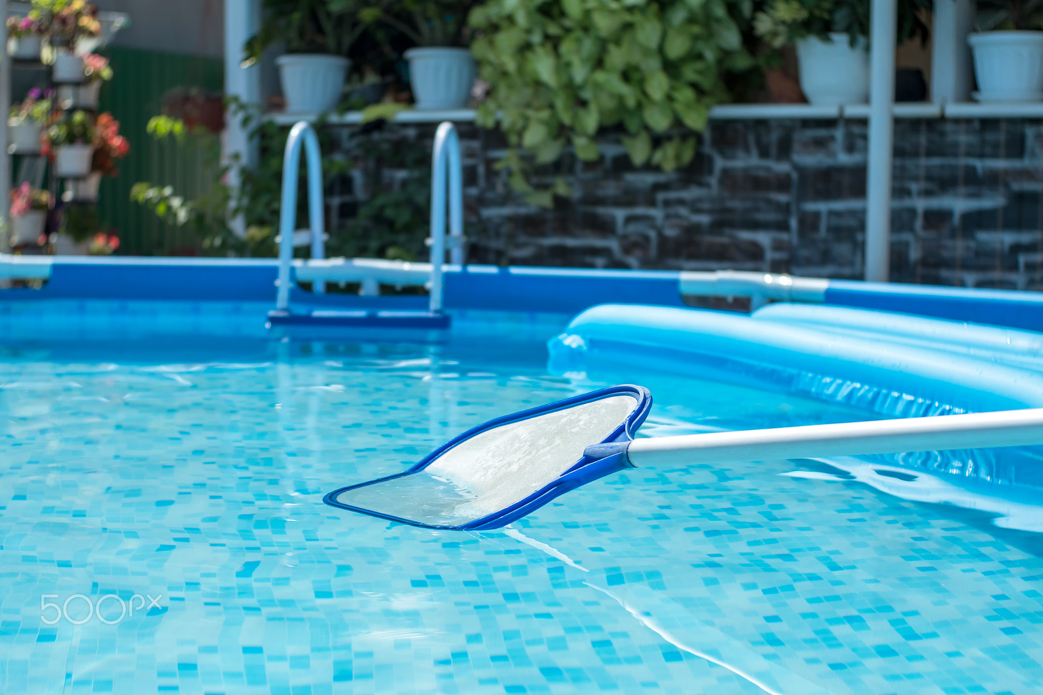 Net-skimmer in a clear water pool with an inflatable mattress