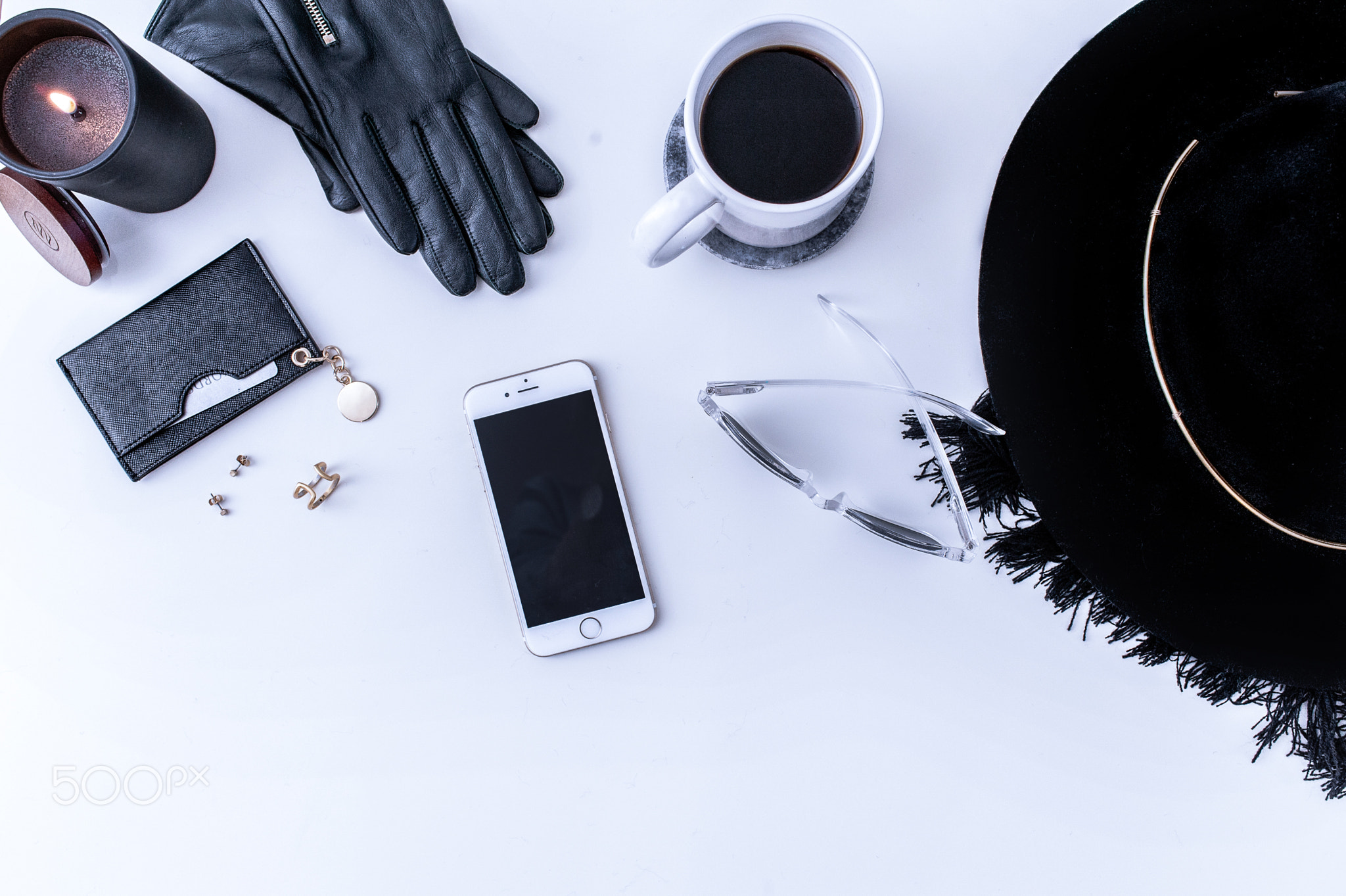 A white mug with black coffee on a white countertop. There are white