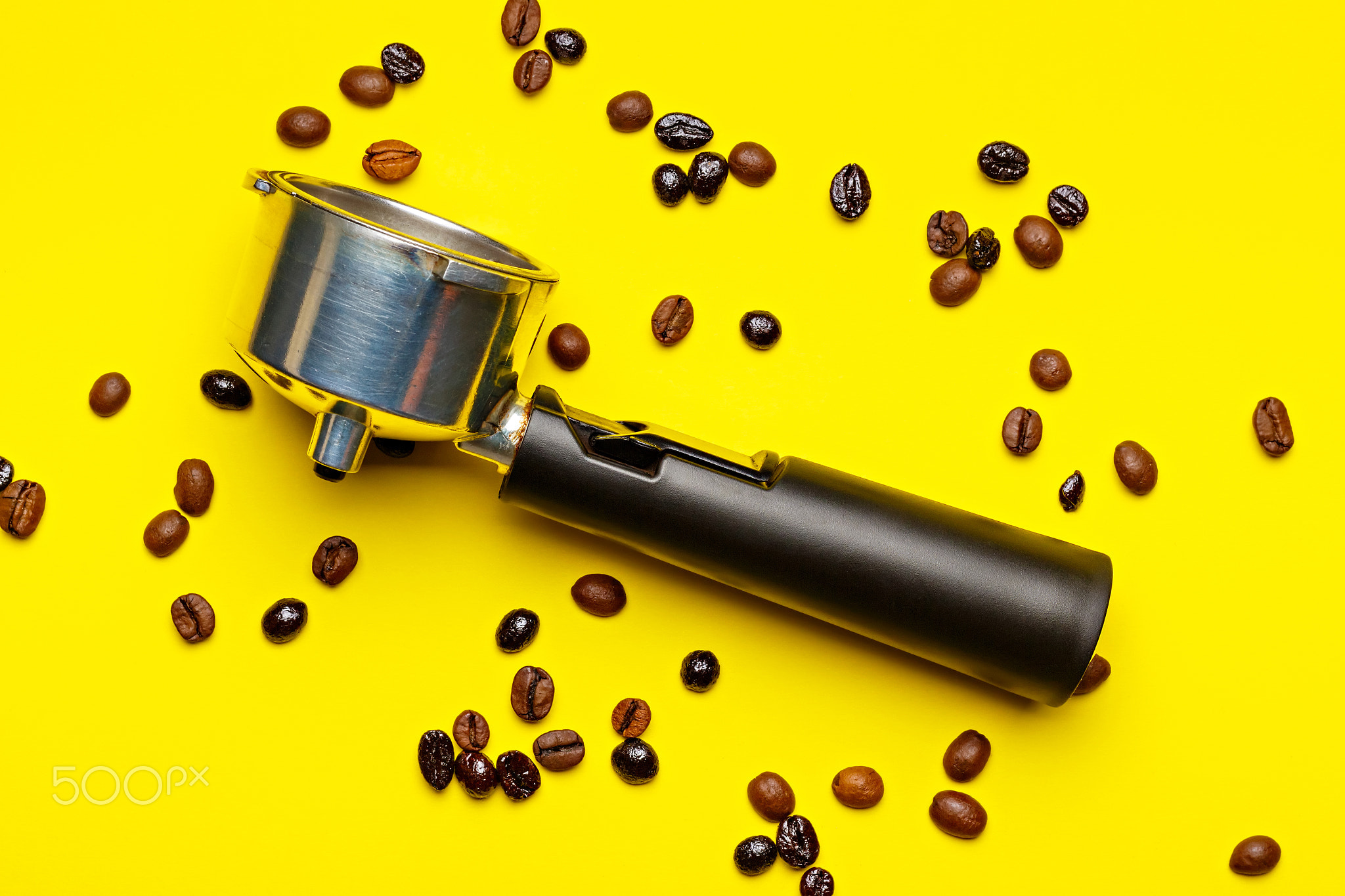 Espresso machine filter surrounded by coffee beans.