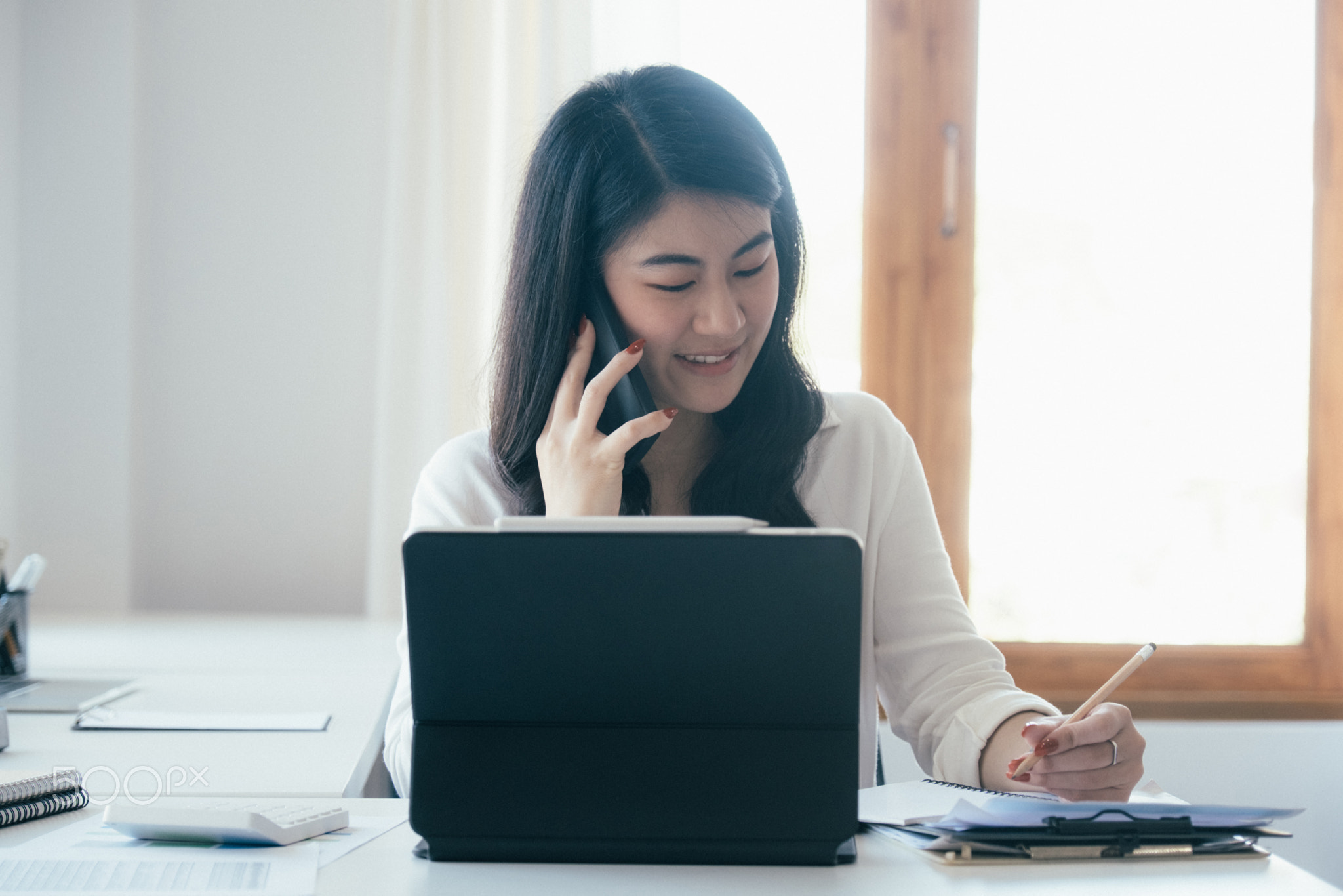 Young businesswoman talking with customer on mobile phone