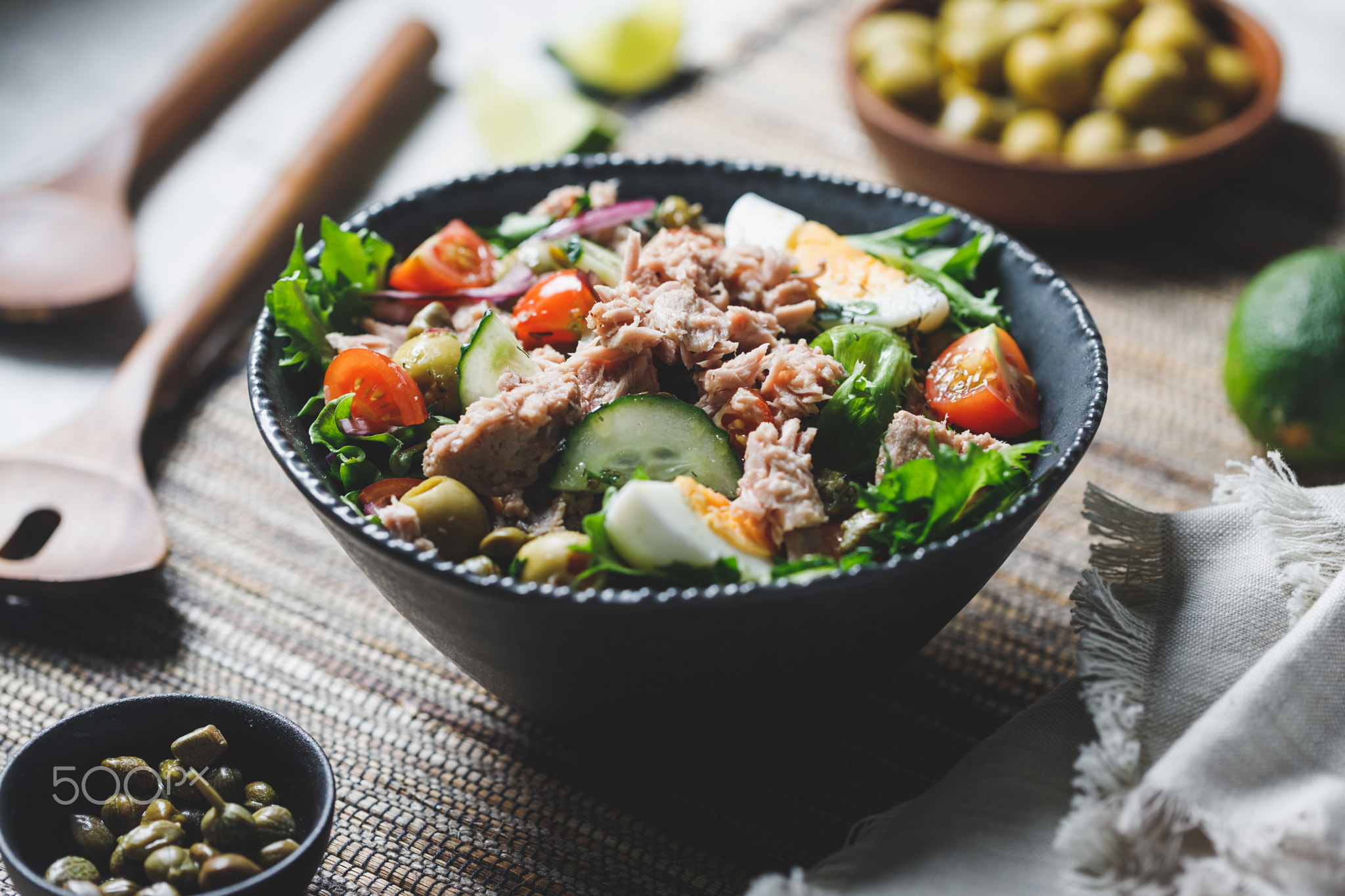 Canned tuna salad with fresh vegetables, capers and olives