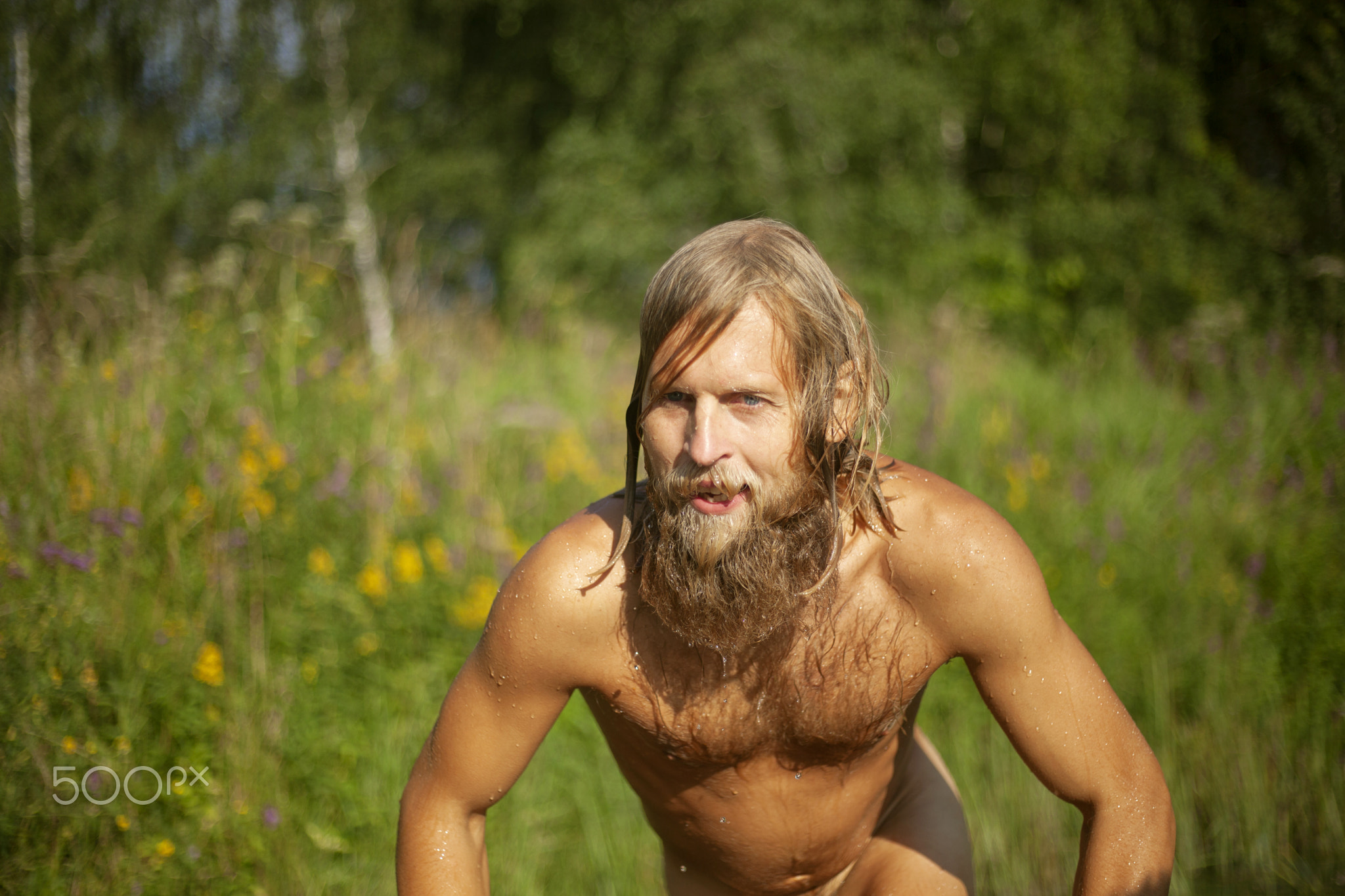 White guy with thick beard was swimming in lake.