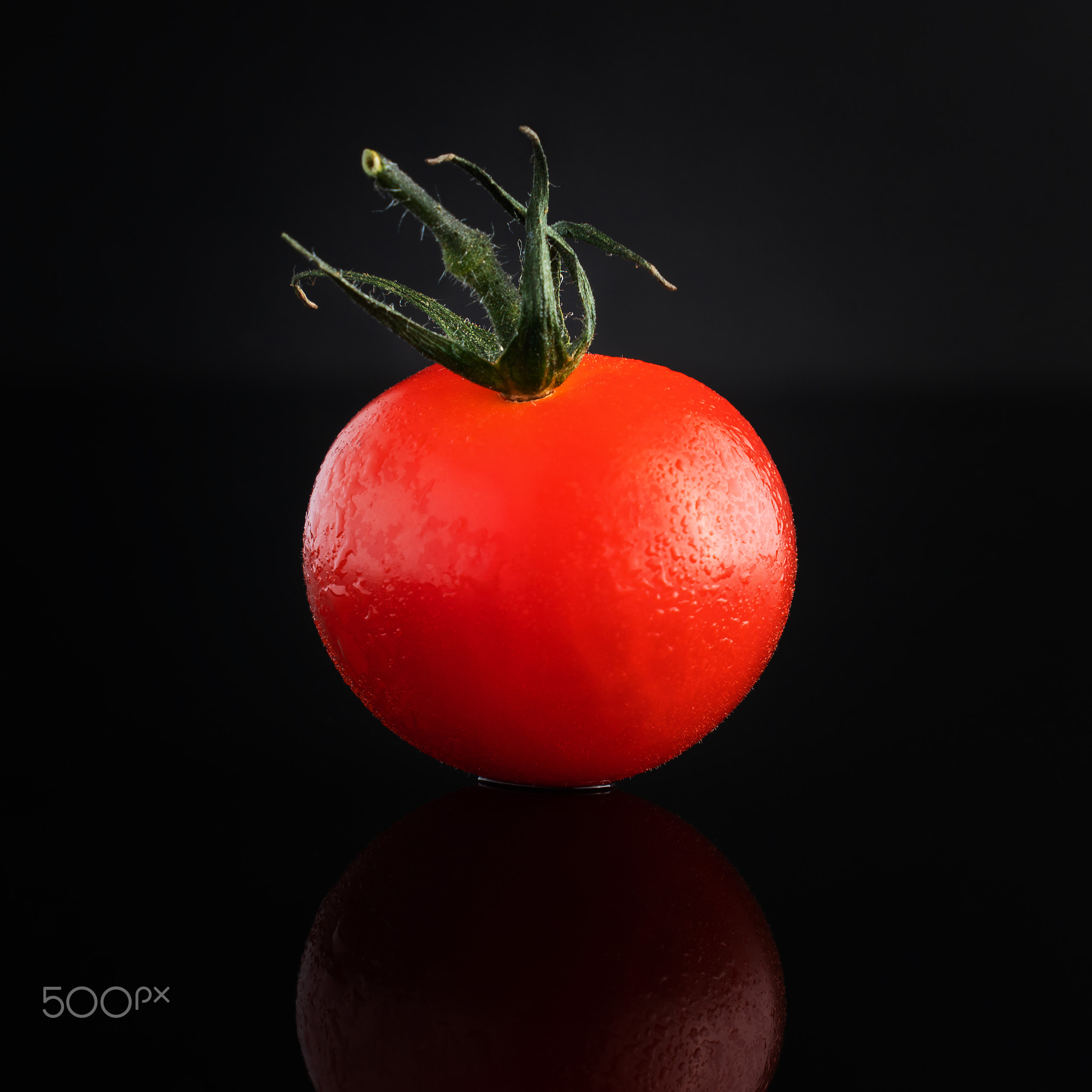 Fresh cherry tomato on a black background