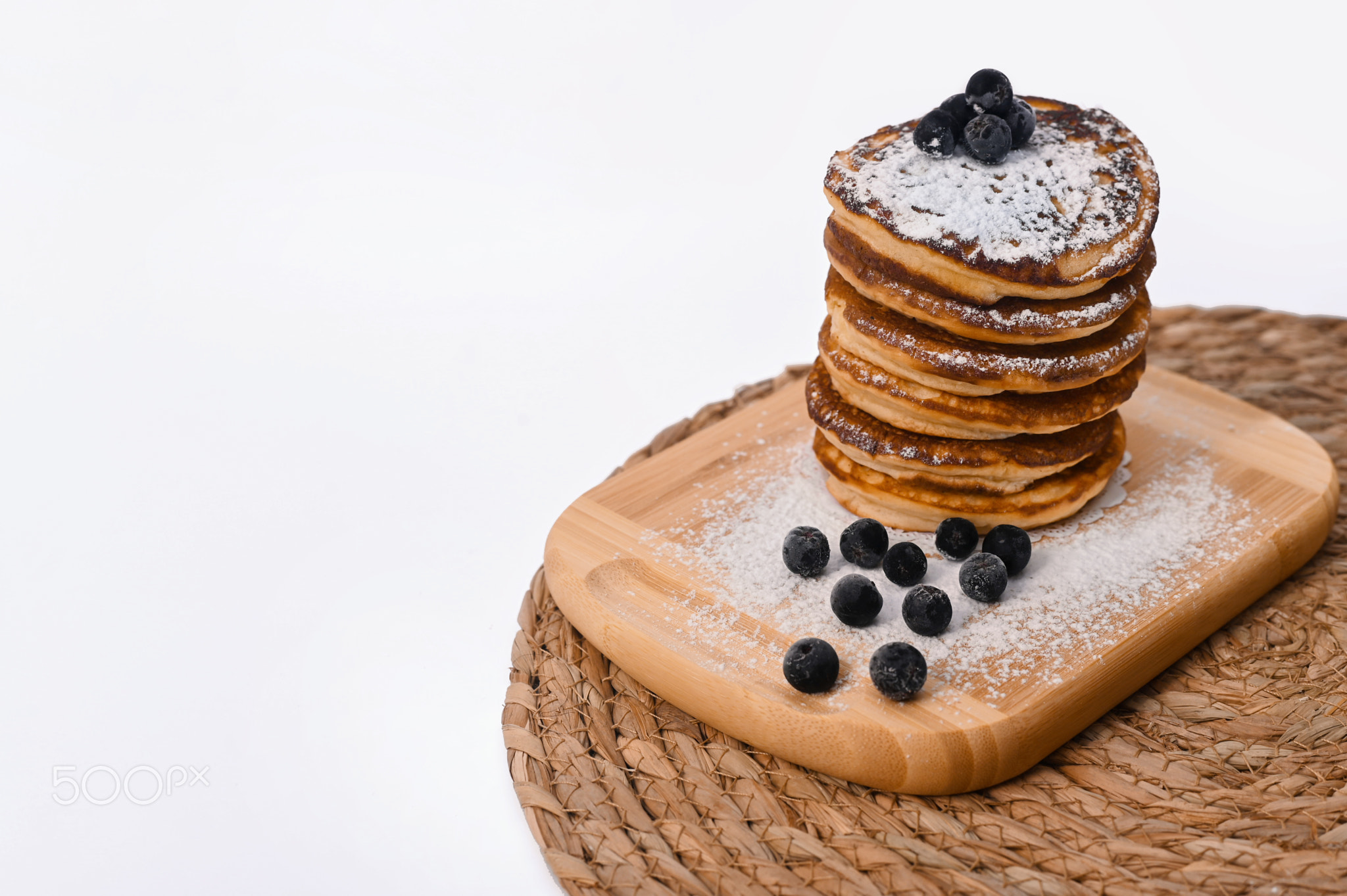 A stack of pancakes with on a wooden board. on a white background.
