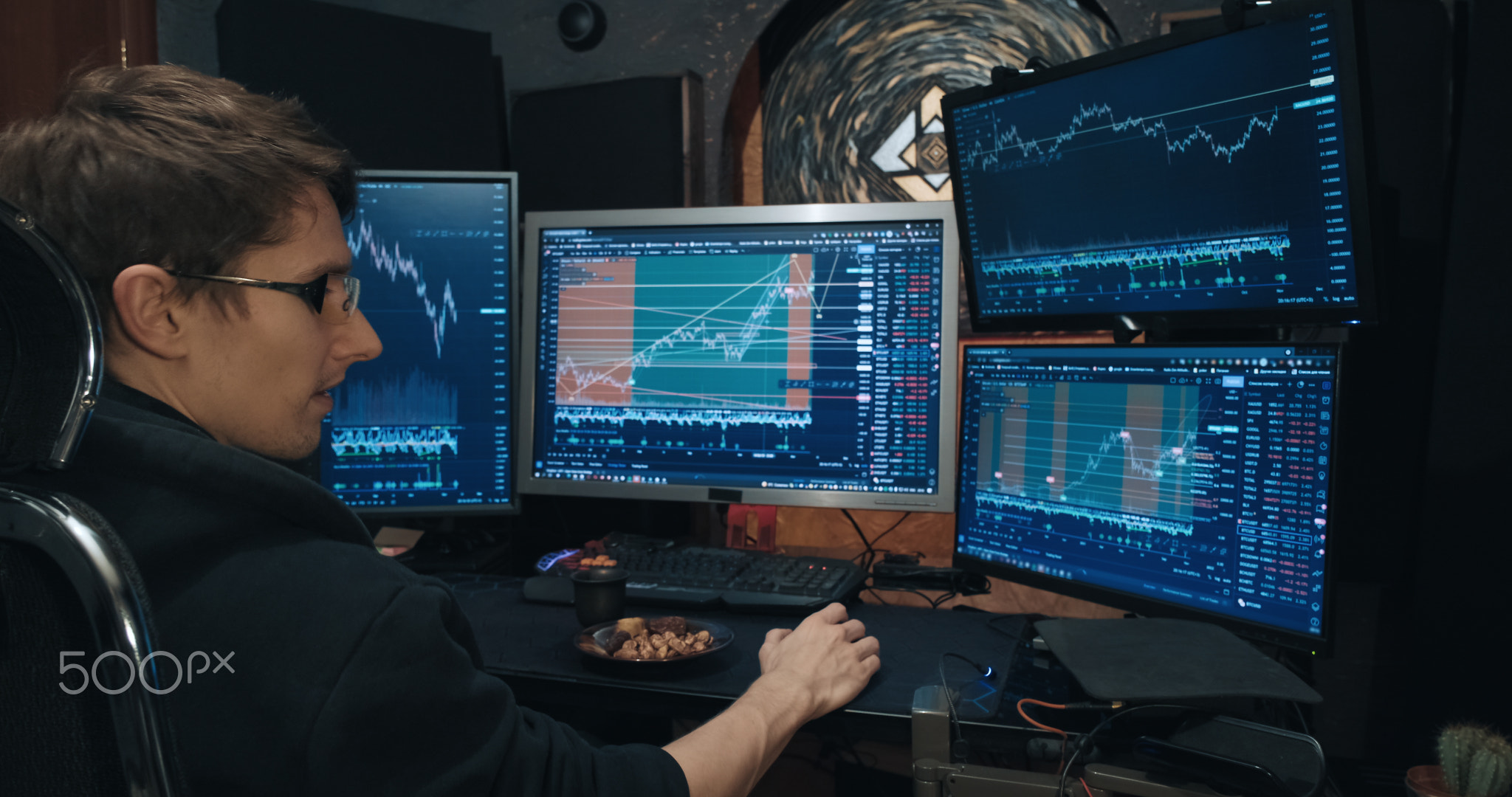 Male trader, freelancer on stock exchange trades options and eats nuts