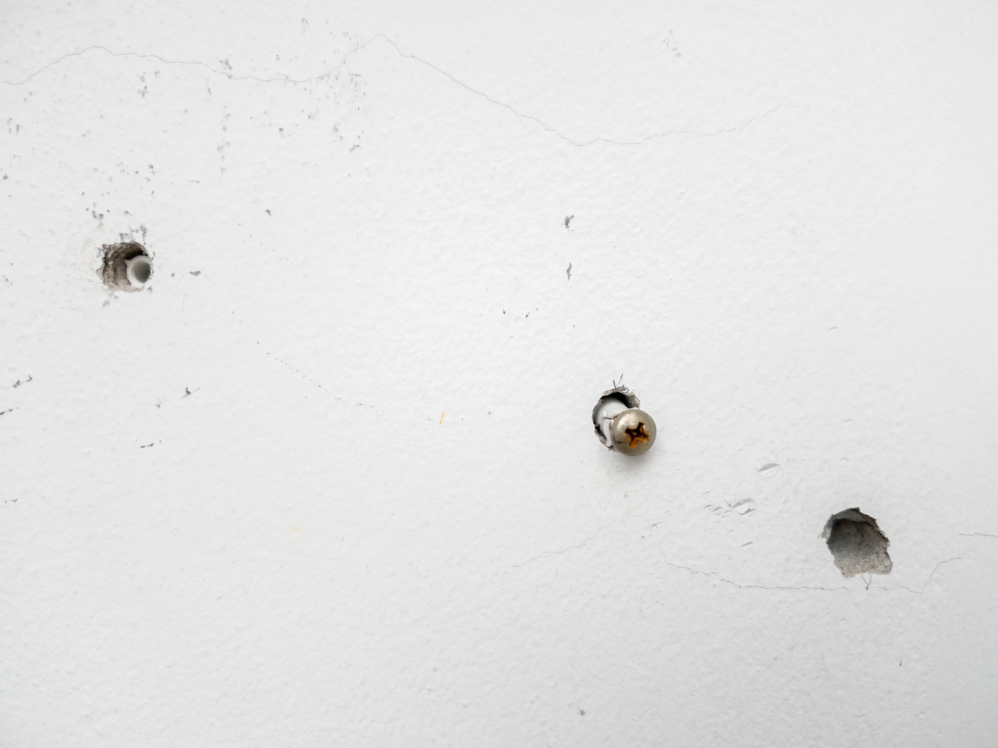 The small hole with the plastic cleat in the concrete wall.