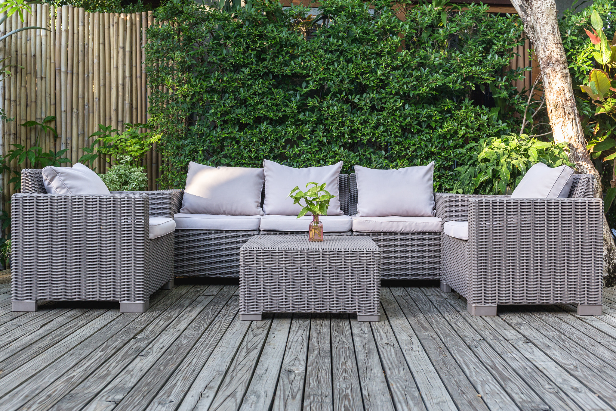 Large terrace patio with rattan garden furniture on wooden floor.