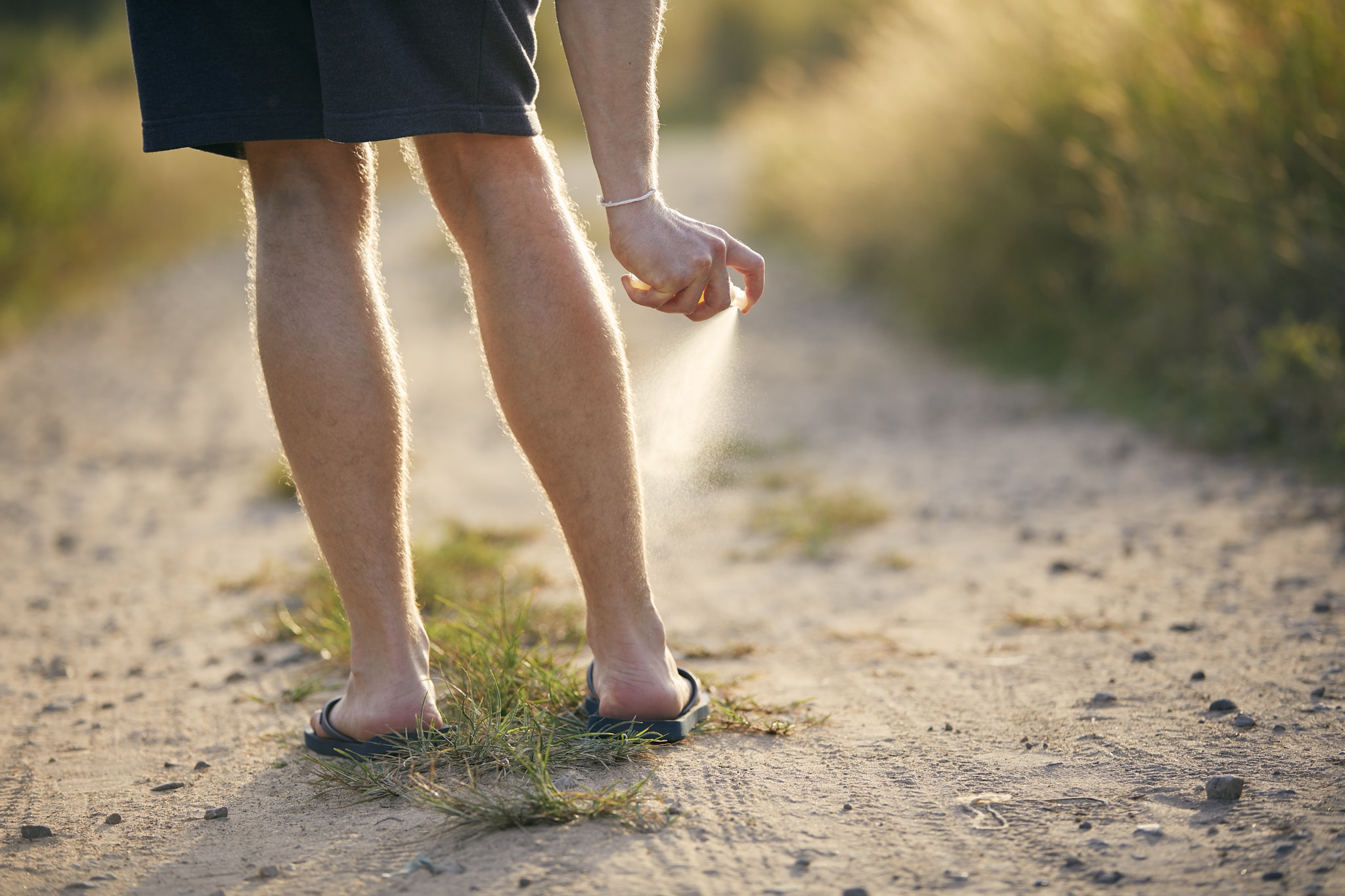 Man applying insect repellent on his legs\r