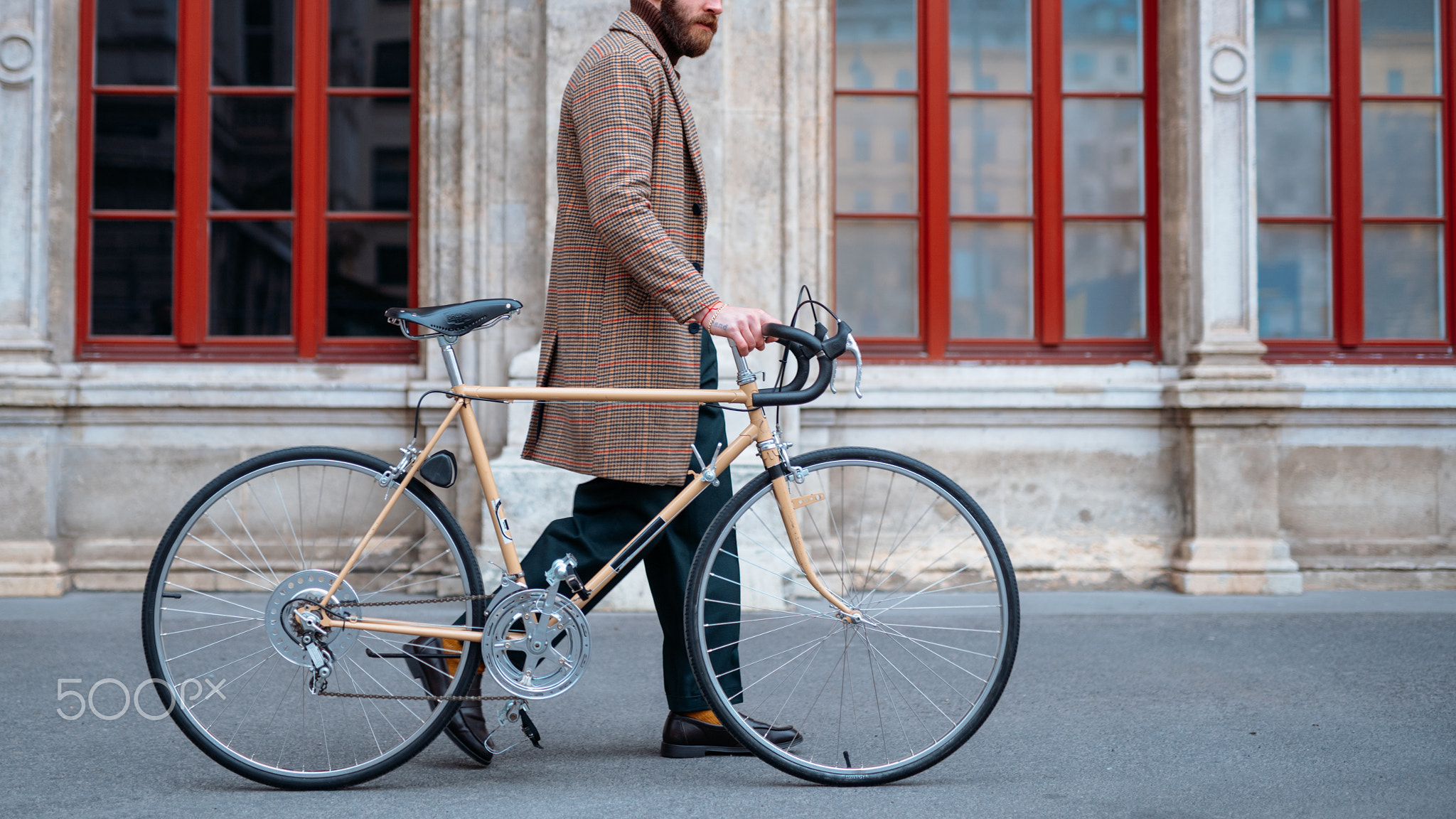 Midsection of walking hipster with bicycle. Eco friendly transport in