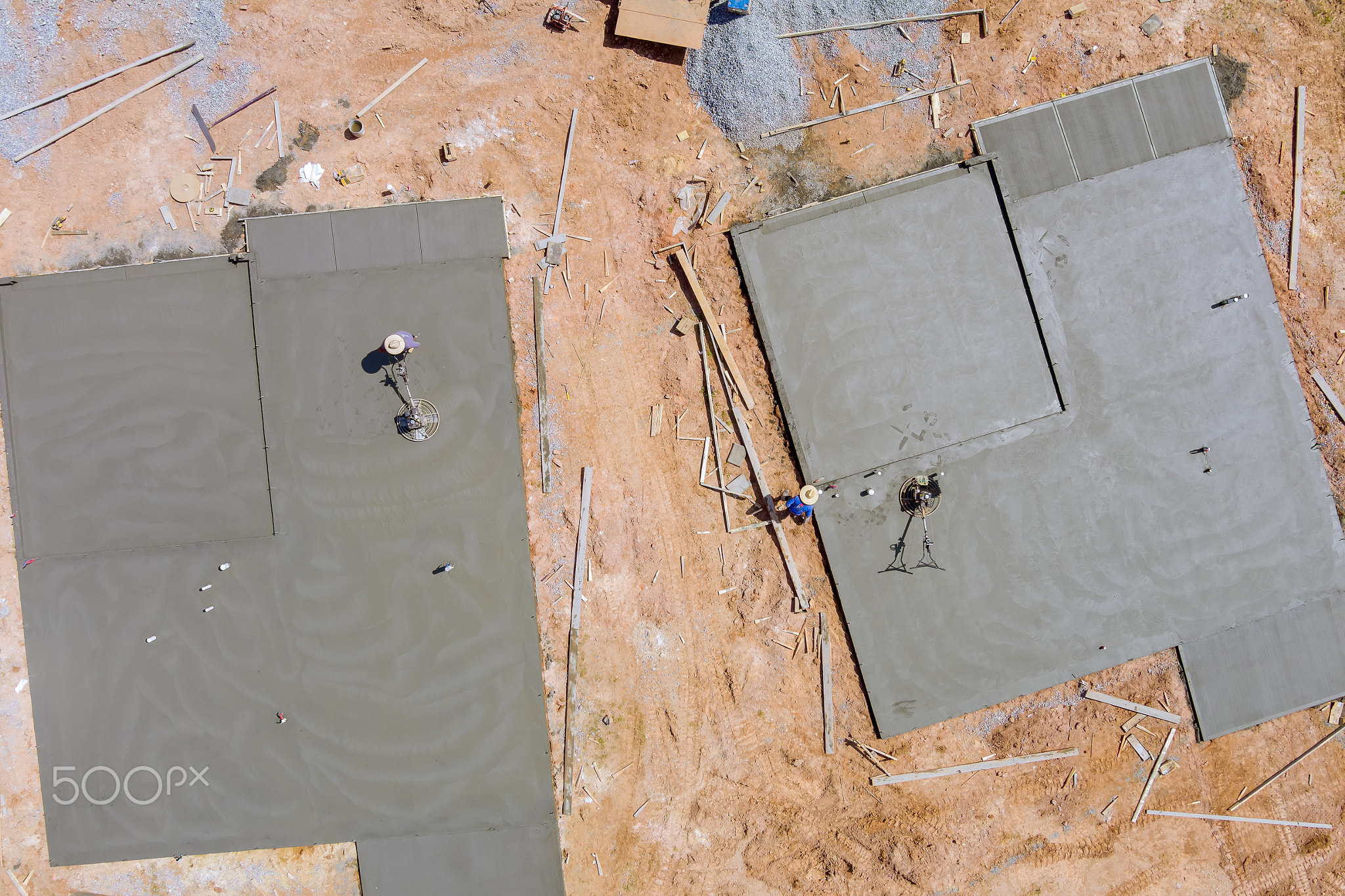 Aerial view of worker performing polishing cement screed foundation on