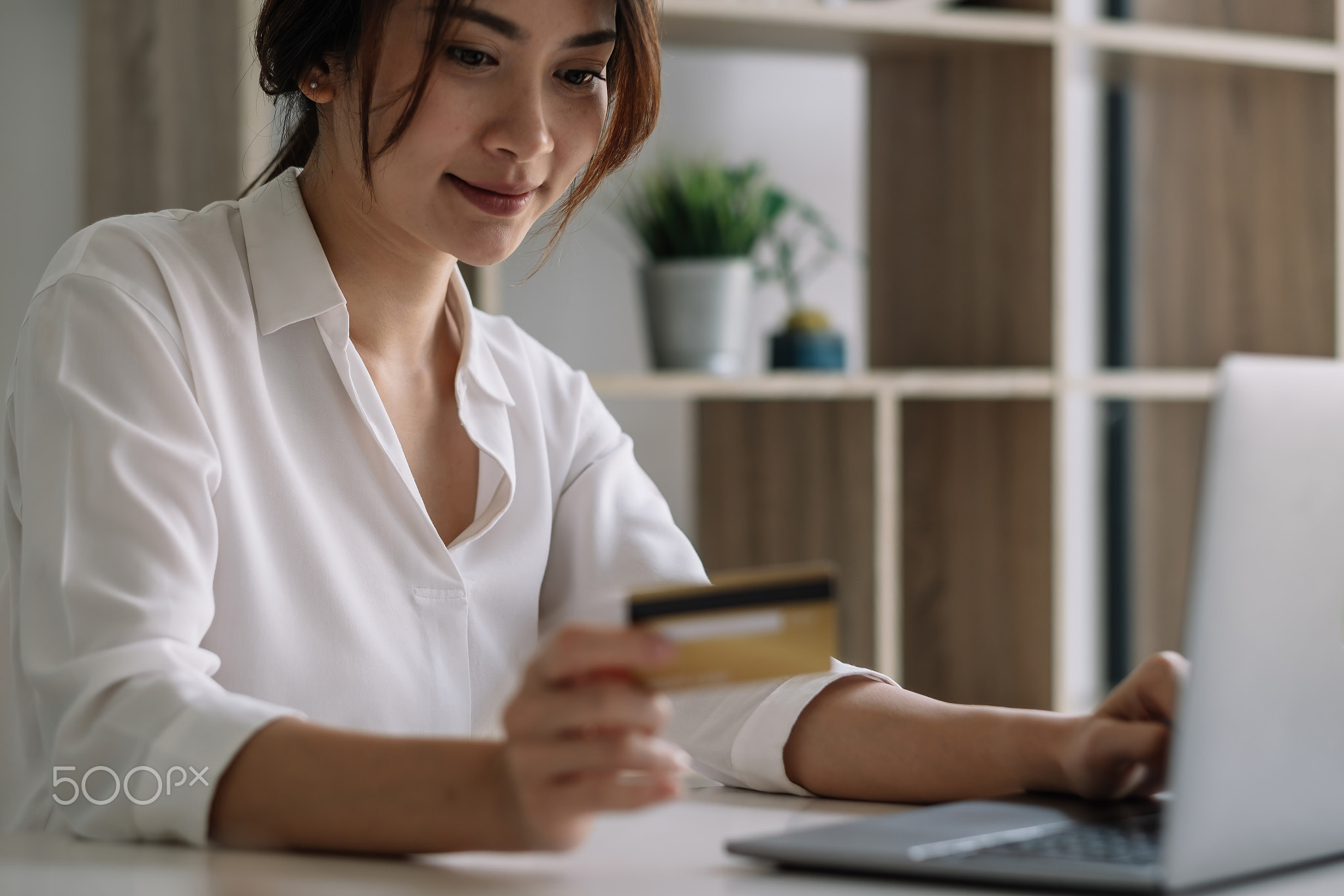 Happy woman using laptop computer and credit card for shopping online